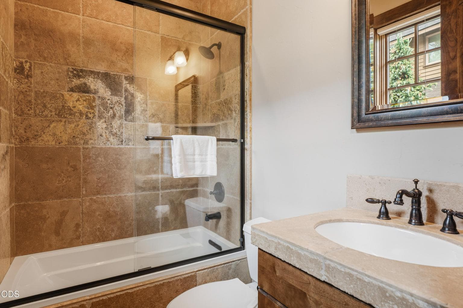 The adjoining guest bathroom features a tiled tub/shower surround.