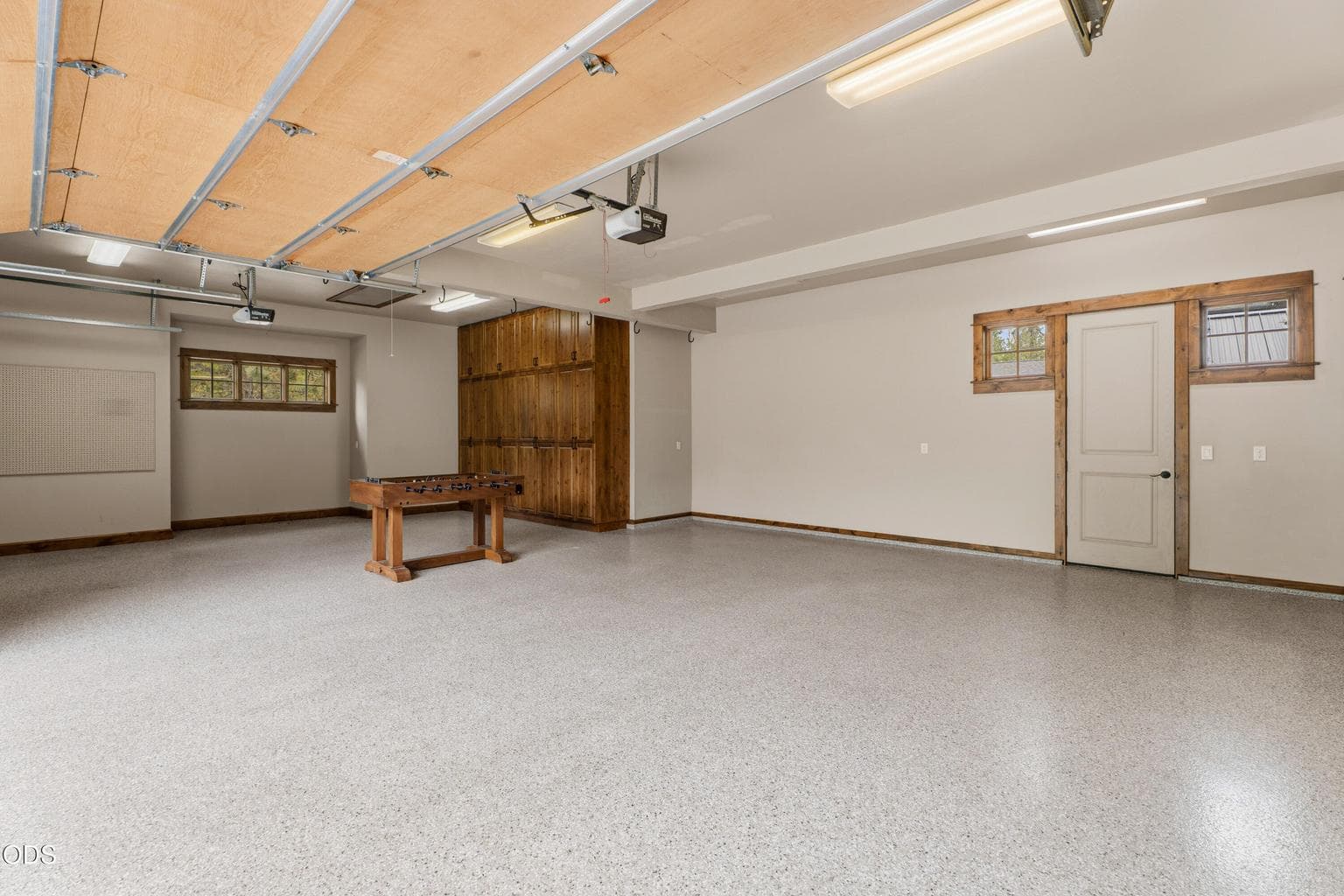 The oversized three-car garage features epoxy floors, extensive built-in cabinetry, and abundant storage, providing exceptional space for vehicles, outdoor gear, and workshop projects.