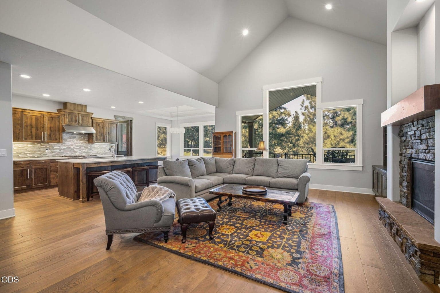 Open-concept living room with vaulted ceilings, fireplace, and golf course views.