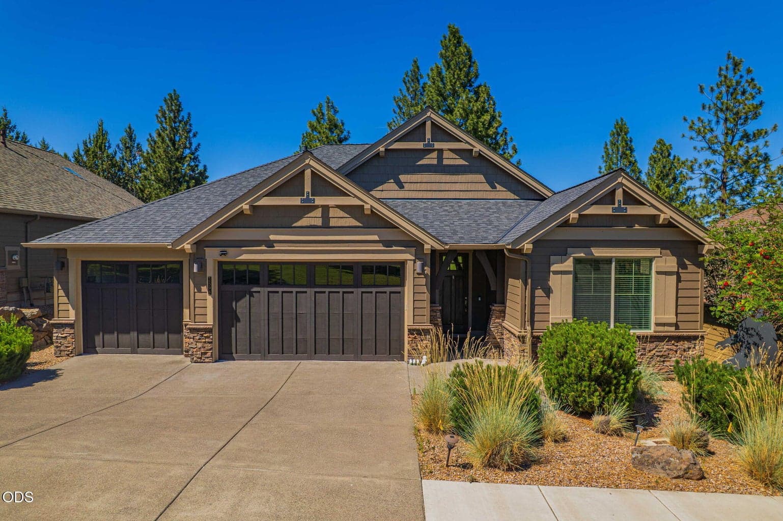 NW Bend craftsman exterior with three-car garage and low-maintenance landscaping.