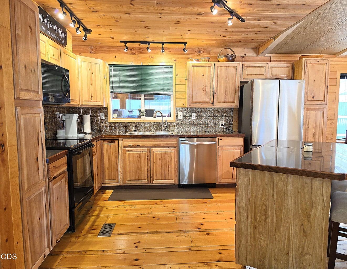 Kitchen has hickory cabinets, pine flooring, and tile countertops