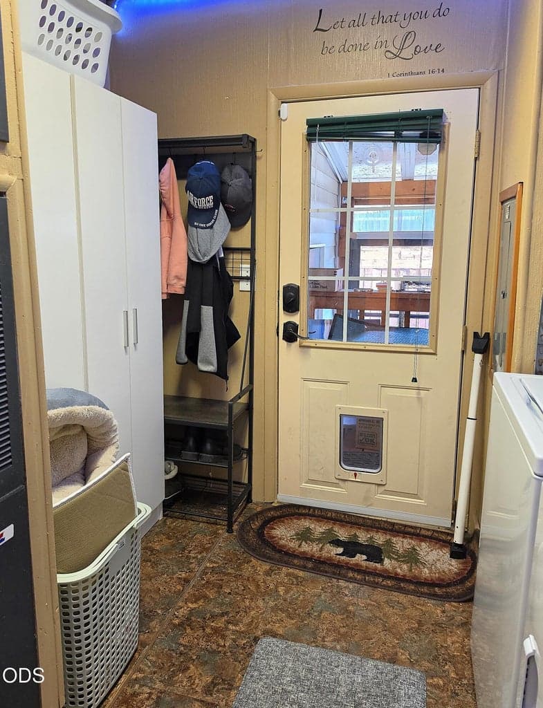 Additional storage cabinets will stay with the home. Door leads to the carport and bonus enclosed space