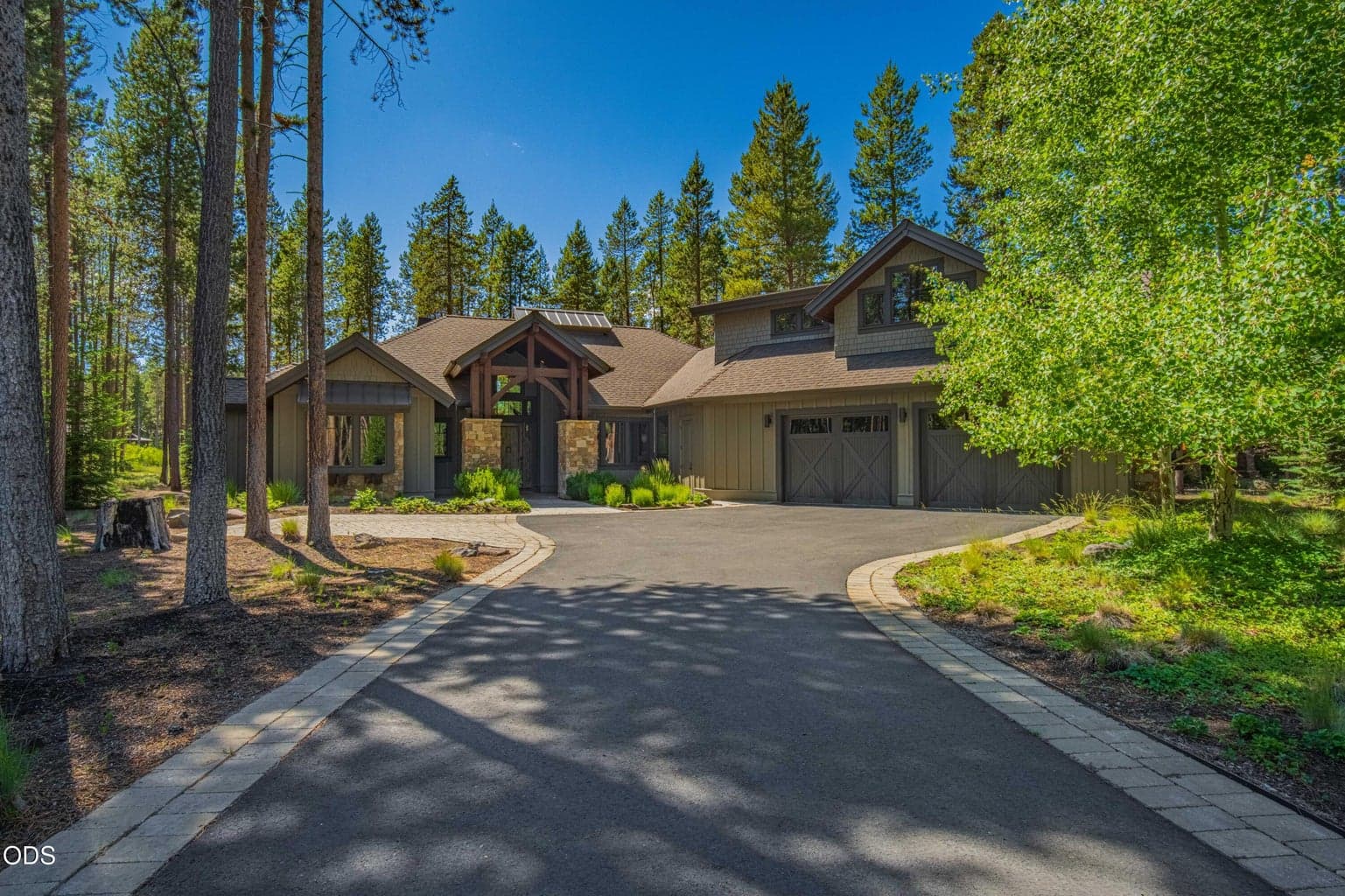 The arrival experience is quietly impressive, with a private drive framed by mature pines, natural landscaping, and the refined High Desert contemporary architecture of this Caldera Springs retreat.
