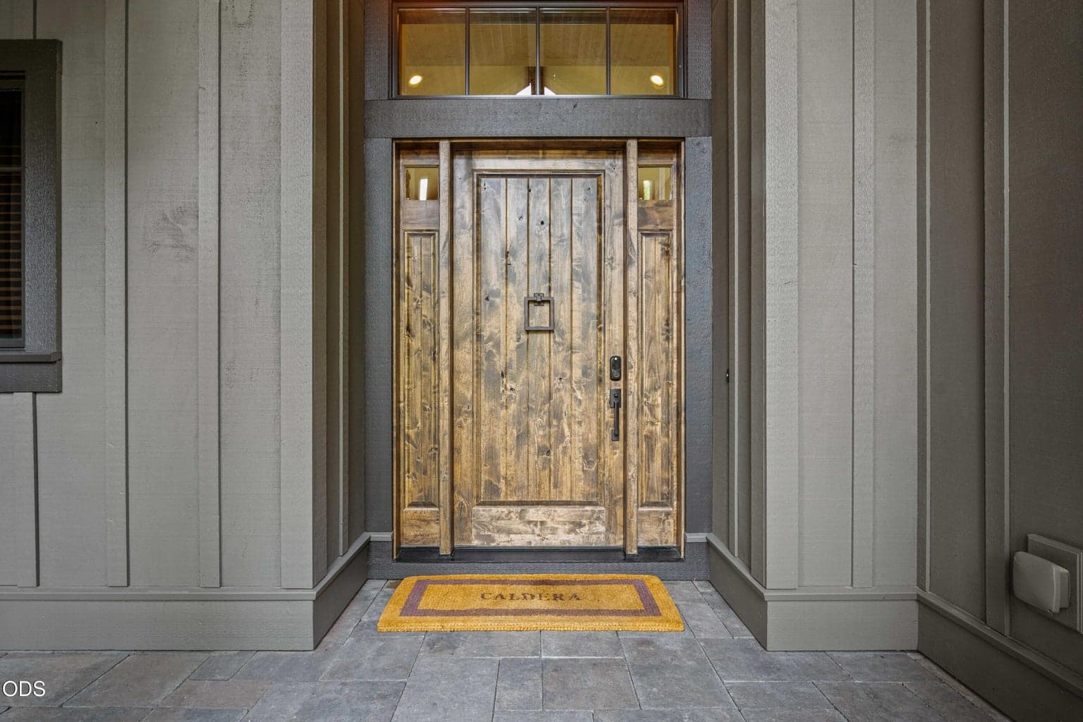 A richly textured wood front door offers the first glimpse of the craftsmanship carried throughout the home, pairing rustic Northwest character with refined Caldera Springs style.
