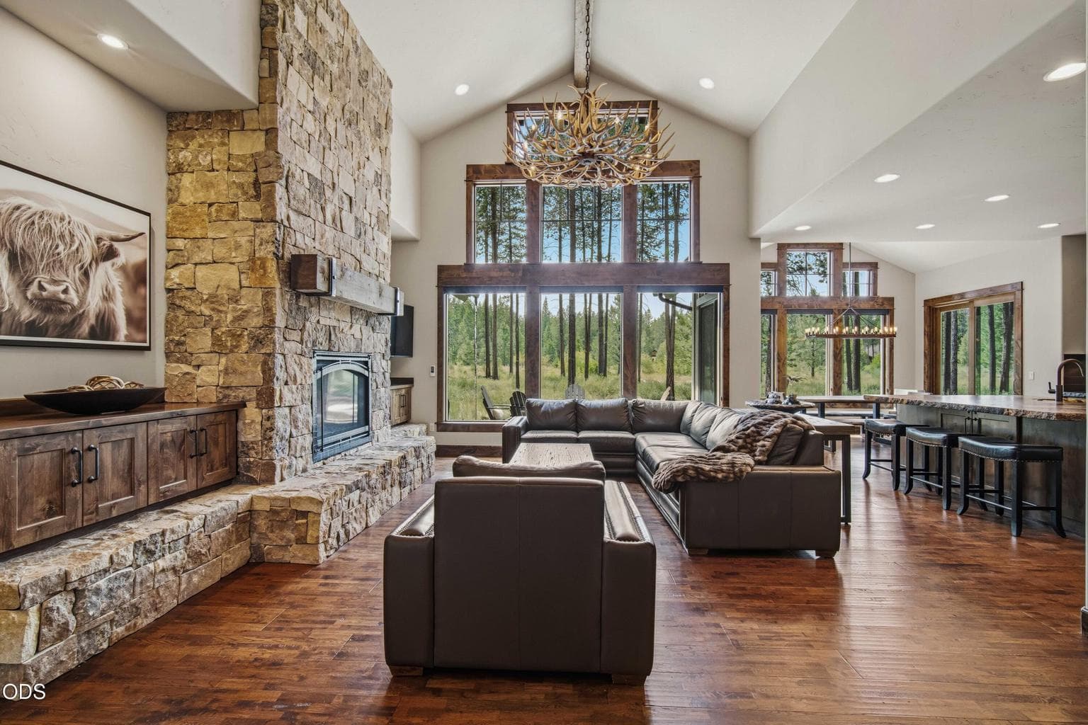 Expansive windows frame tranquil views toward the spring-fed nature corridor, allowing the great room to feel deeply connected to the mature pines, flowing water, and protected open space beyond.