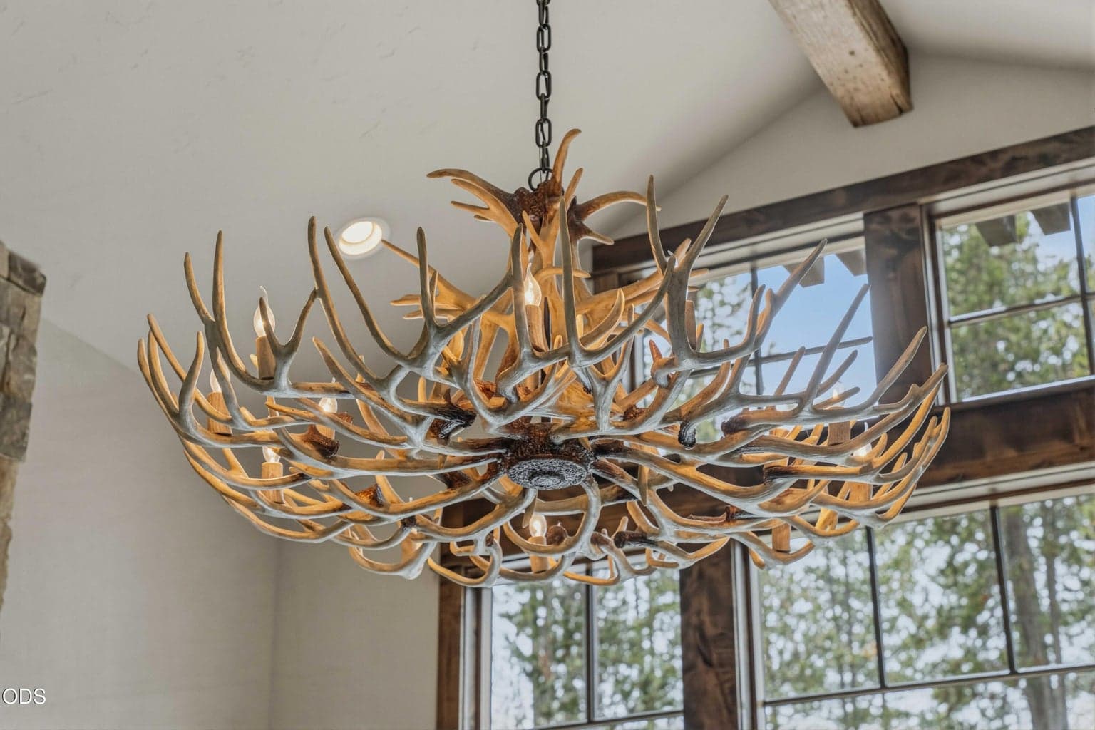 The antler-style chandelier adds a sculptural High Desert note, bringing organic texture and a sense of place to the vaulted great room.