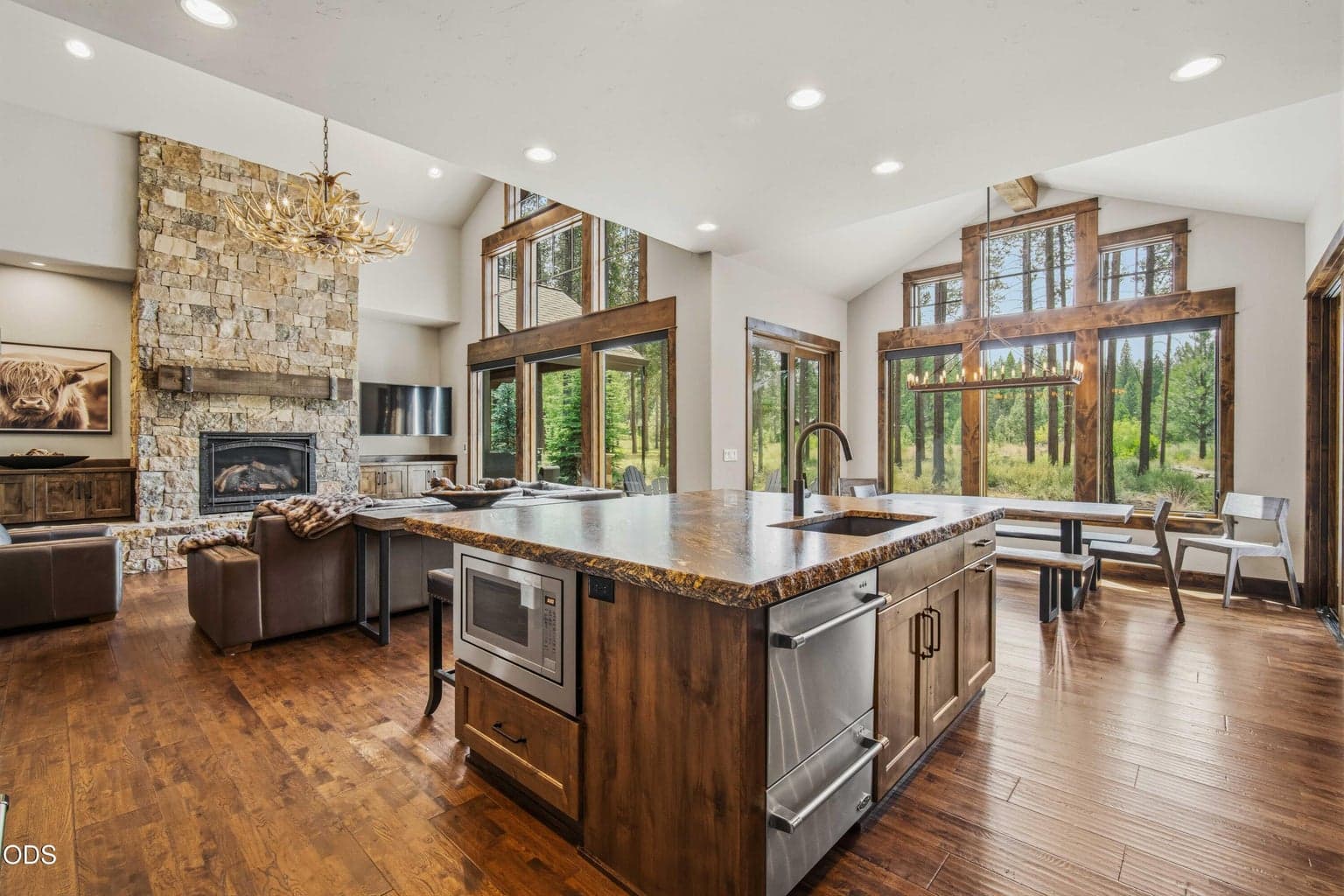 Expansive glass invites the outdoors in, connecting the kitchen, dining, and living spaces to the protected open space and mature pines just beyond the patio.
