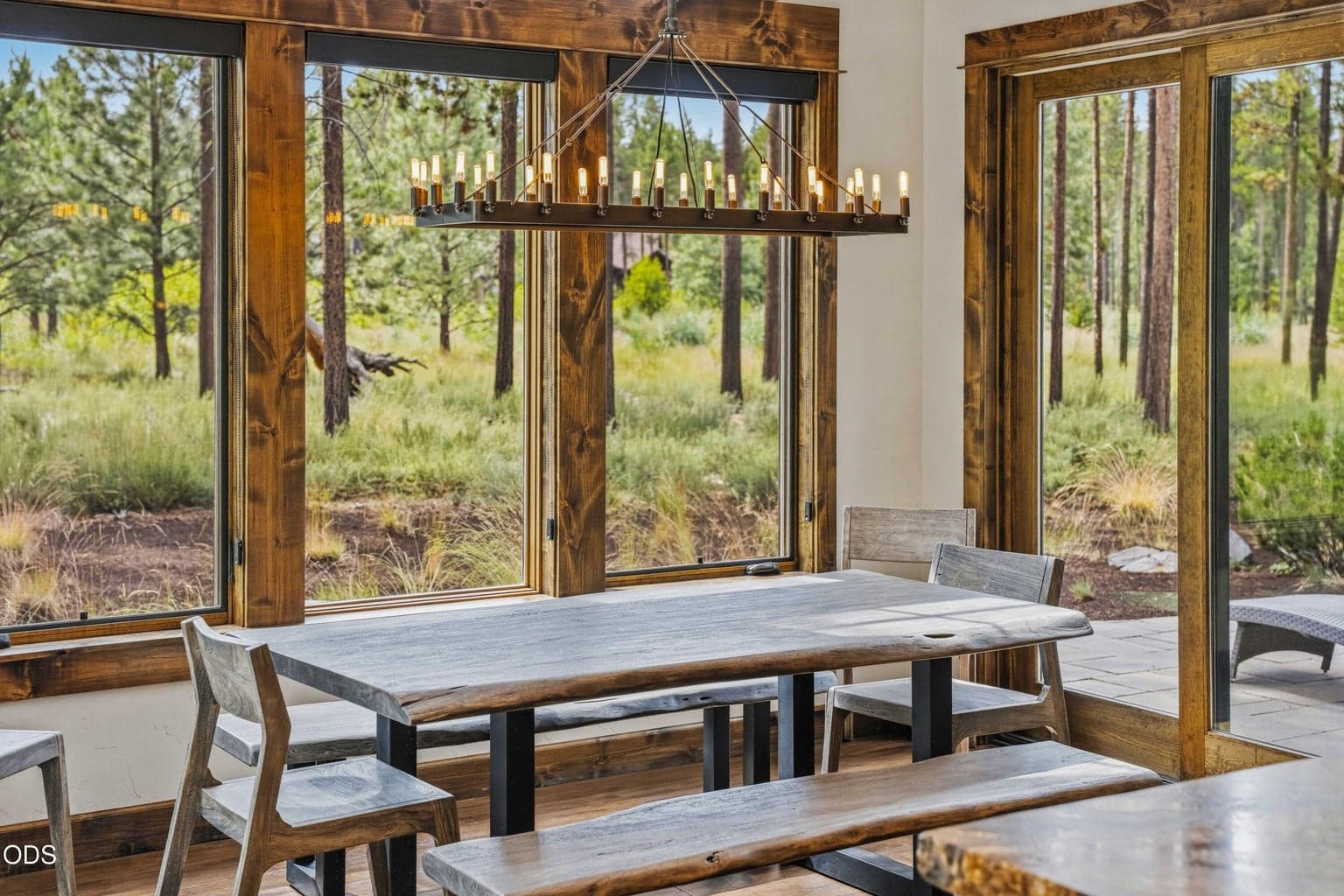 The dining area is surrounded by glass and patio access, allowing indoor meals to feel connected to the natural rhythm of the spring-fed corridor outside.