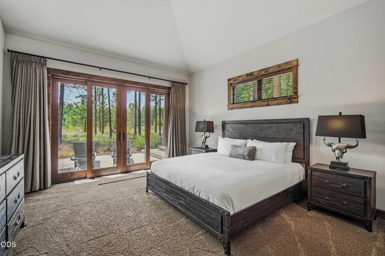 The main-level primary suite opens directly to outdoor living and views of the natural corridor, creating a peaceful retreat within the home.