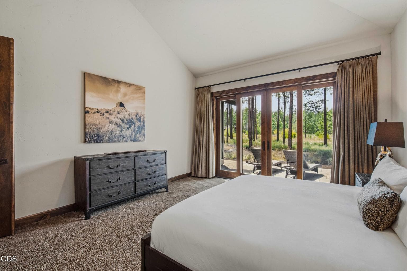 A private patio outlook connects the primary suite to the home’s extraordinary setting, where mature pines and protected open space create a sense of calm.