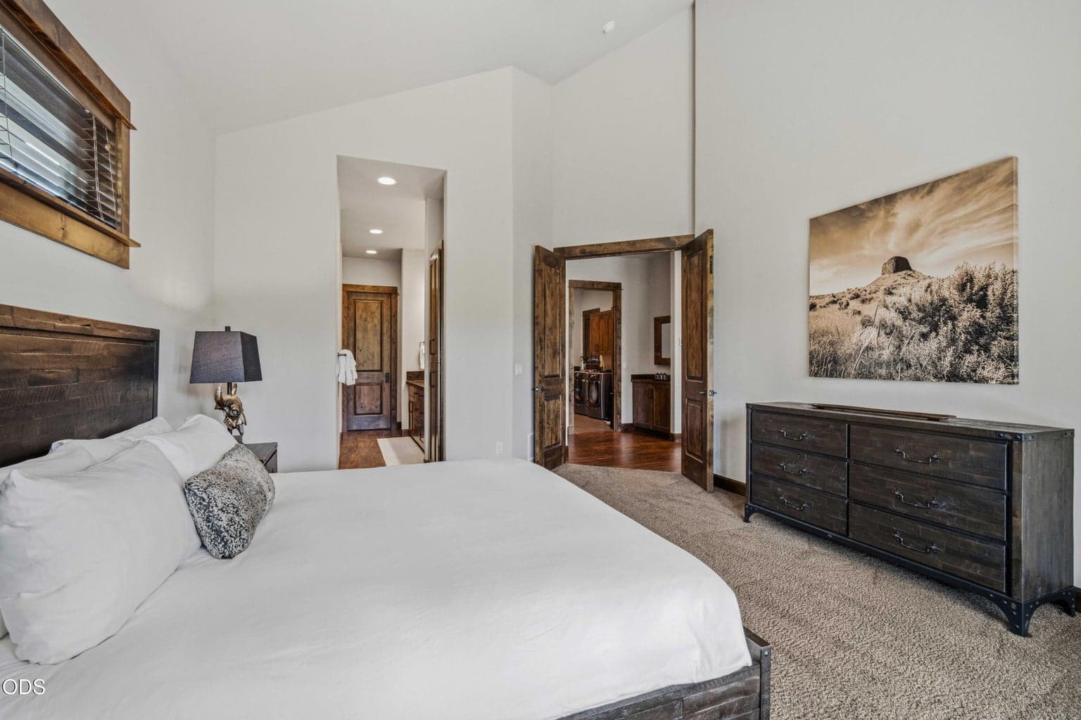The primary suite is thoughtfully arranged with generous volume, warm wood doors and trim, and direct access to the bath and main living areas.