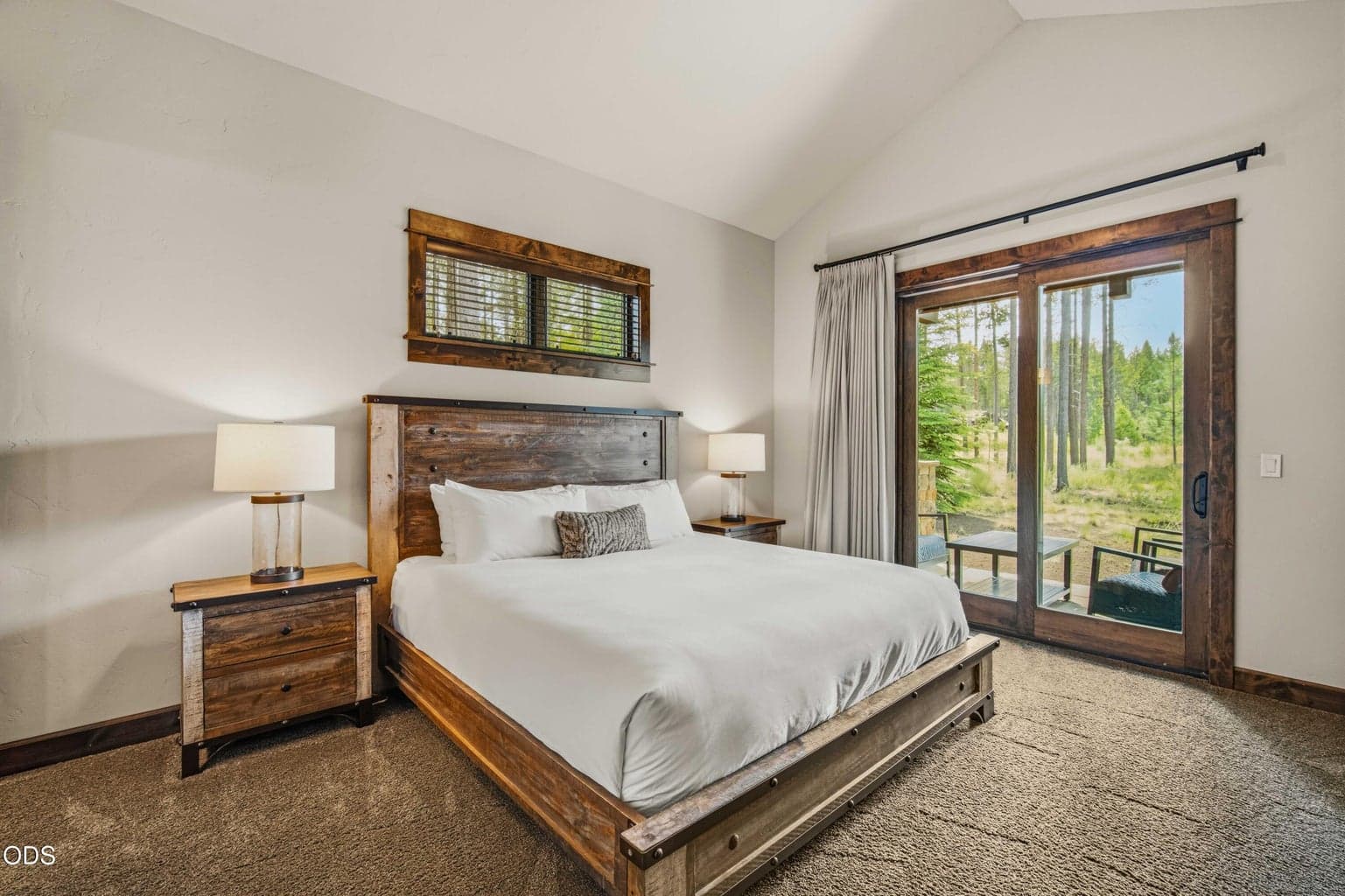 This guest suite opens to the patio and surrounding pines, allowing visitors to experience the same privacy and natural beauty that define the home.