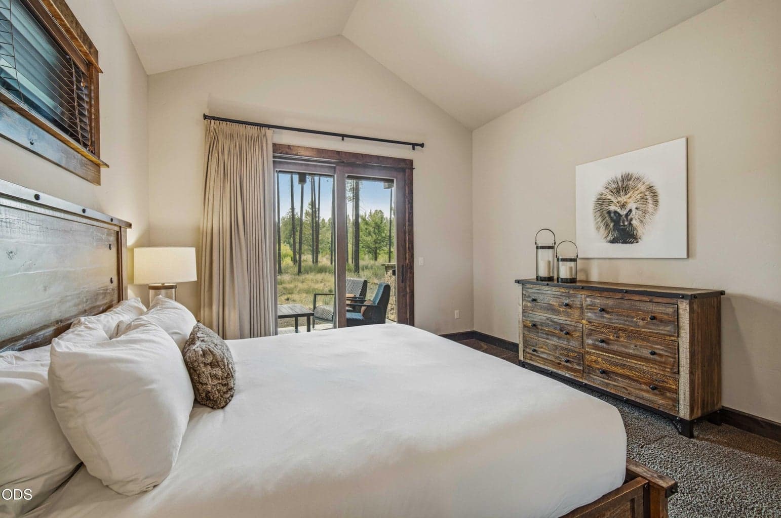 A peaceful guest bedroom frames views toward the trees and natural landscape, reinforcing the home’s rare connection to its protected setting.