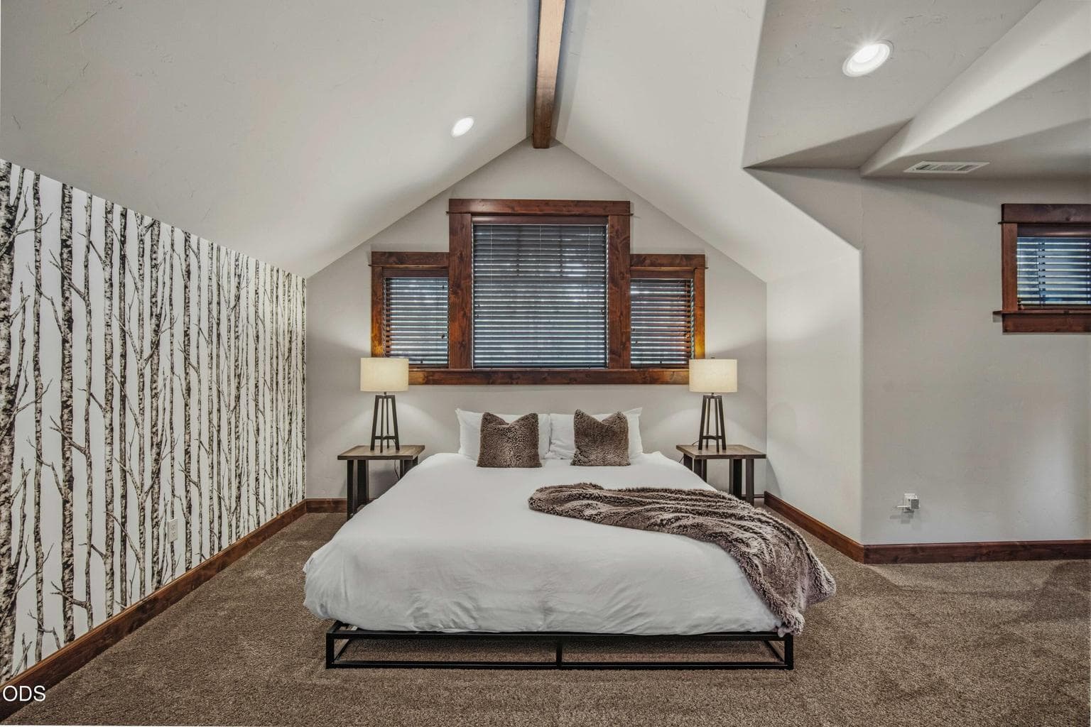 Vaulted ceilings, warm trim, and a spacious layout make the upstairs bedroom area feel private, flexible, and inviting.