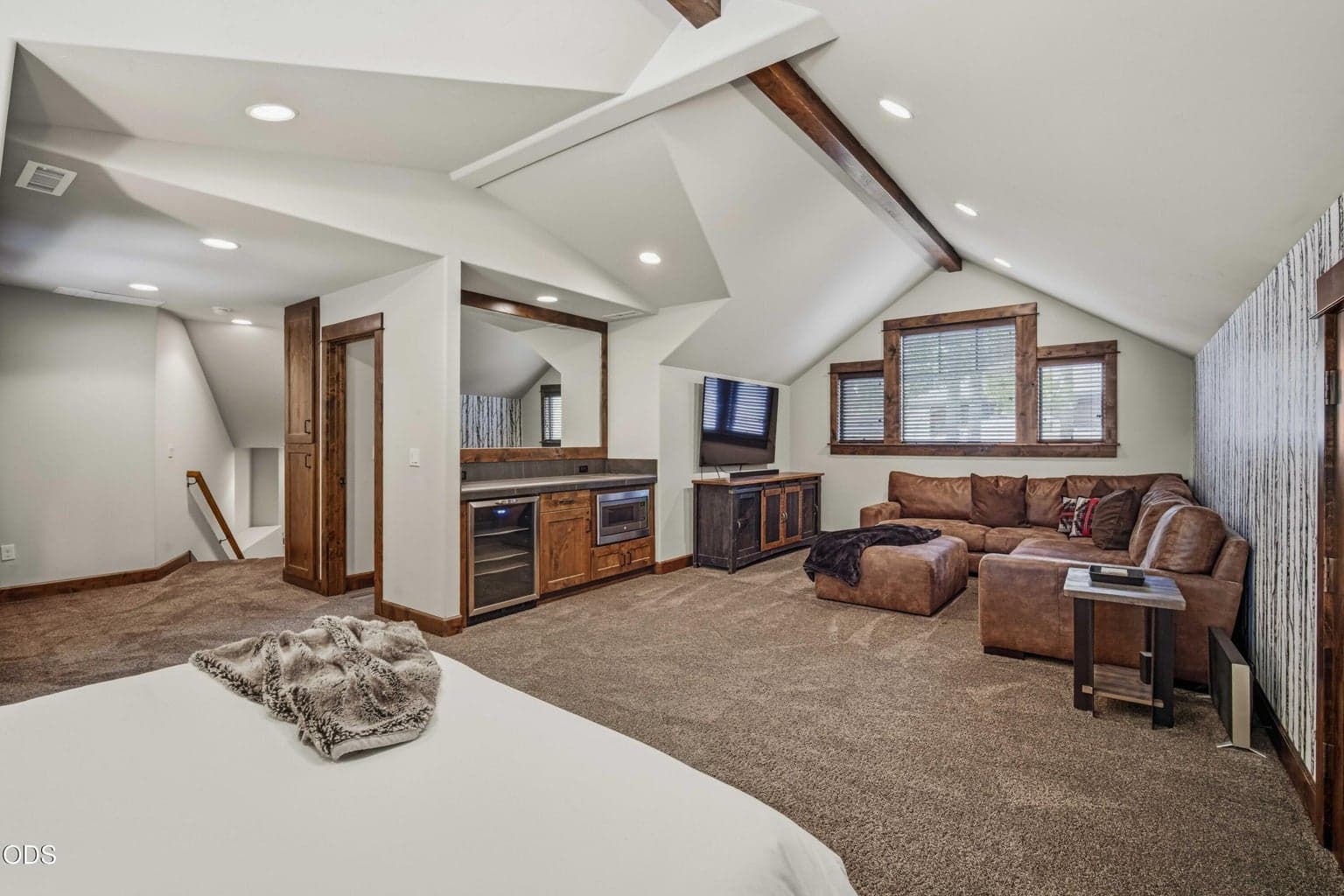 The upstairs bonus room includes a comfortable sitting area, creating a flexible retreat for guests, recreation, or longer stays.