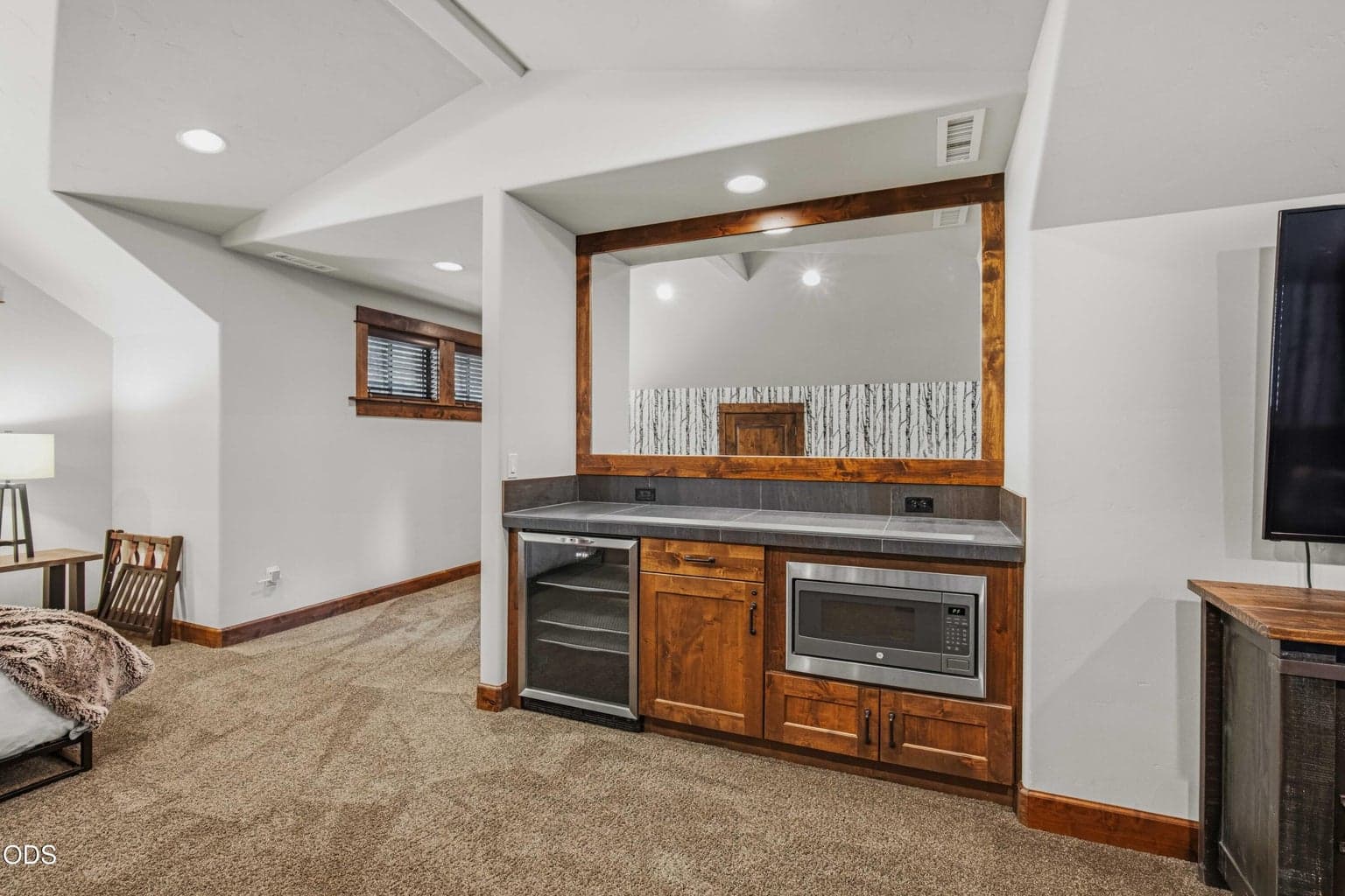 A wet bar with beverage refrigerator and microwave enhances the upstairs bonus room, making it ideal for guests or multi-purpose living.
