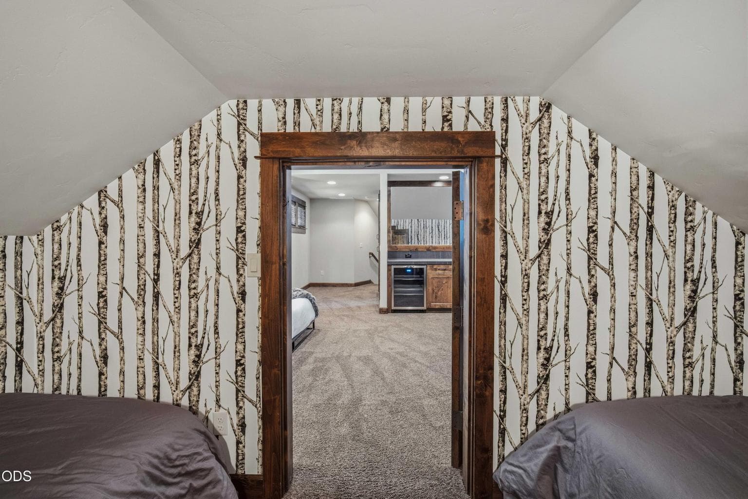 This view shows the connection between the upstairs sleeping nook and the larger bonus room, offering flexible space within the fourth bedroom arrangement.