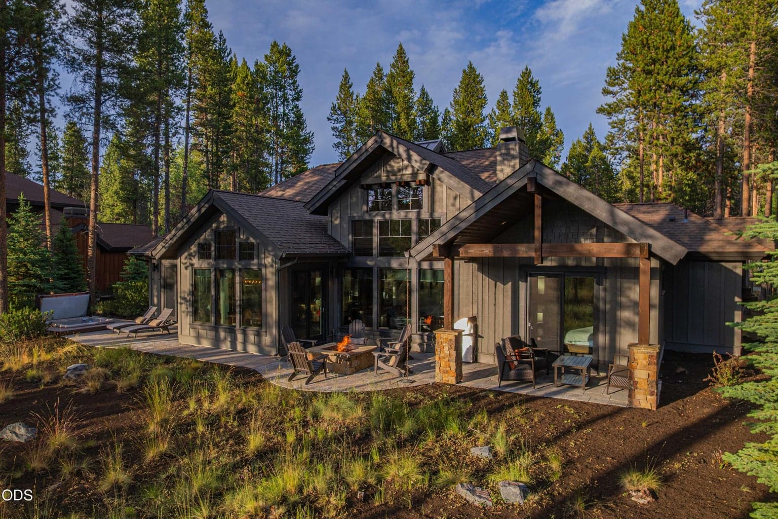 The rear elevation showcases the home’s expansive glass, thoughtful architecture, and intimate relationship with the mature pines and protected corridor.