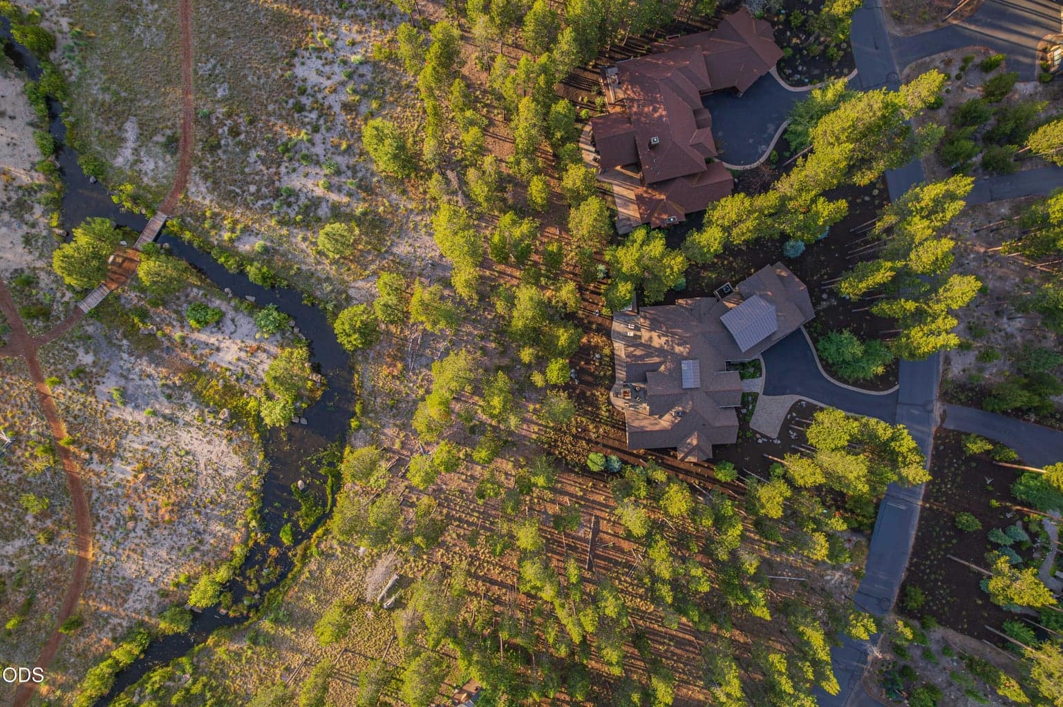 This aerial view shows the relationship between the home and the spring-fed nature corridor, a rare setting where protected open space and refined luxury meet.