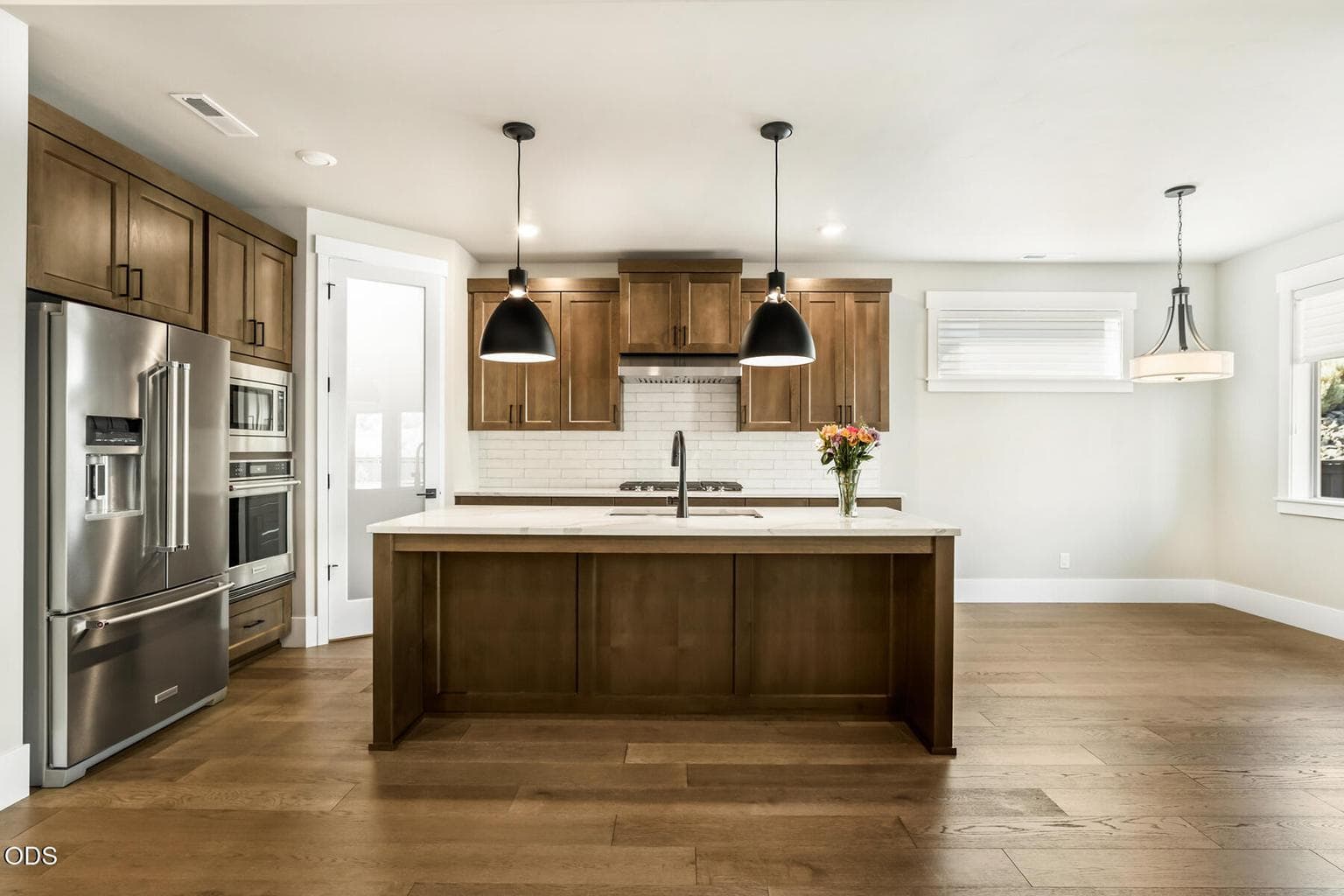 Chef's kitchen with kitchen island, bar seating, and large pantry.