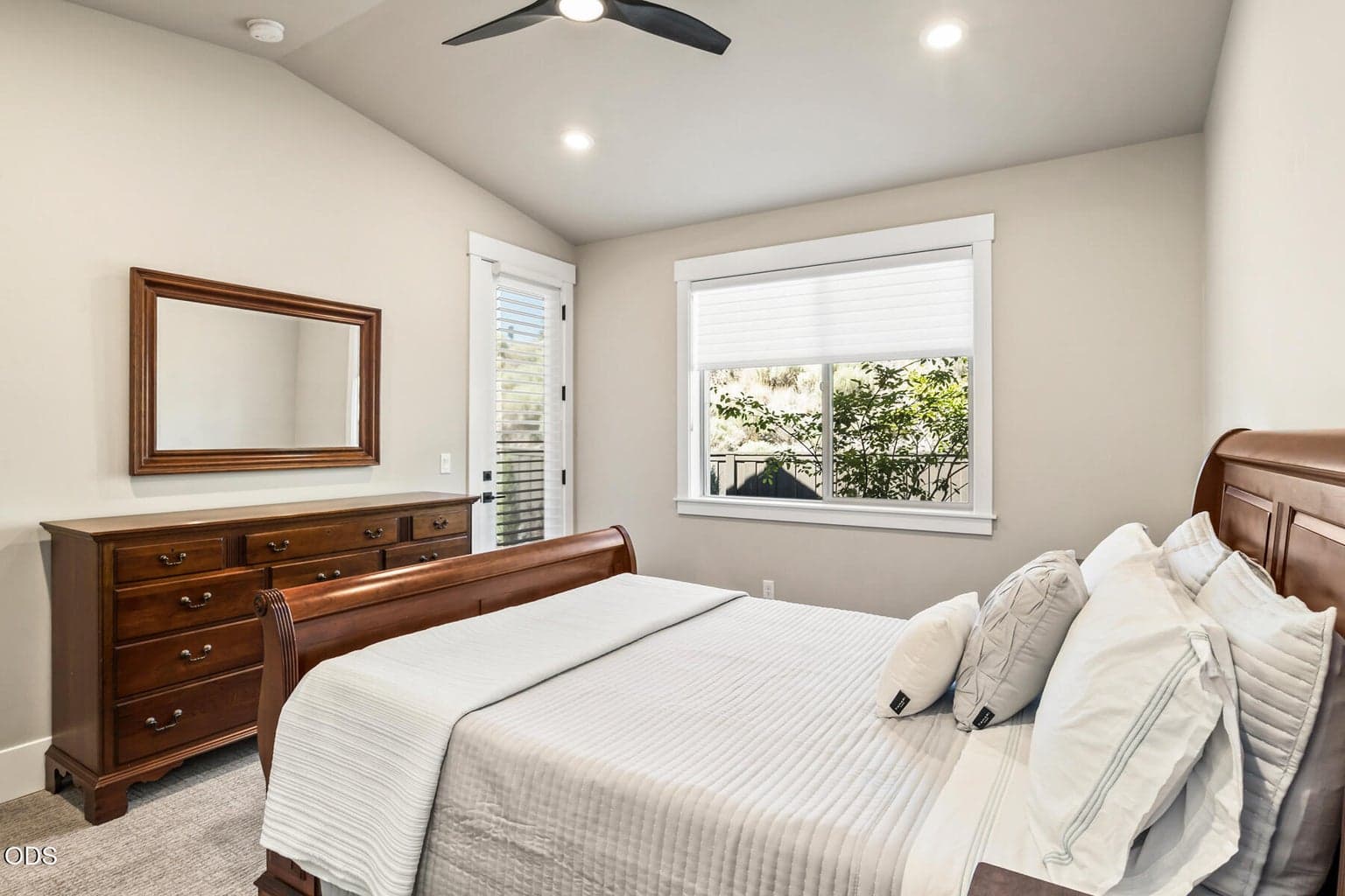 Primary bedroom with vaulted ceilings and access to rear covered patio.