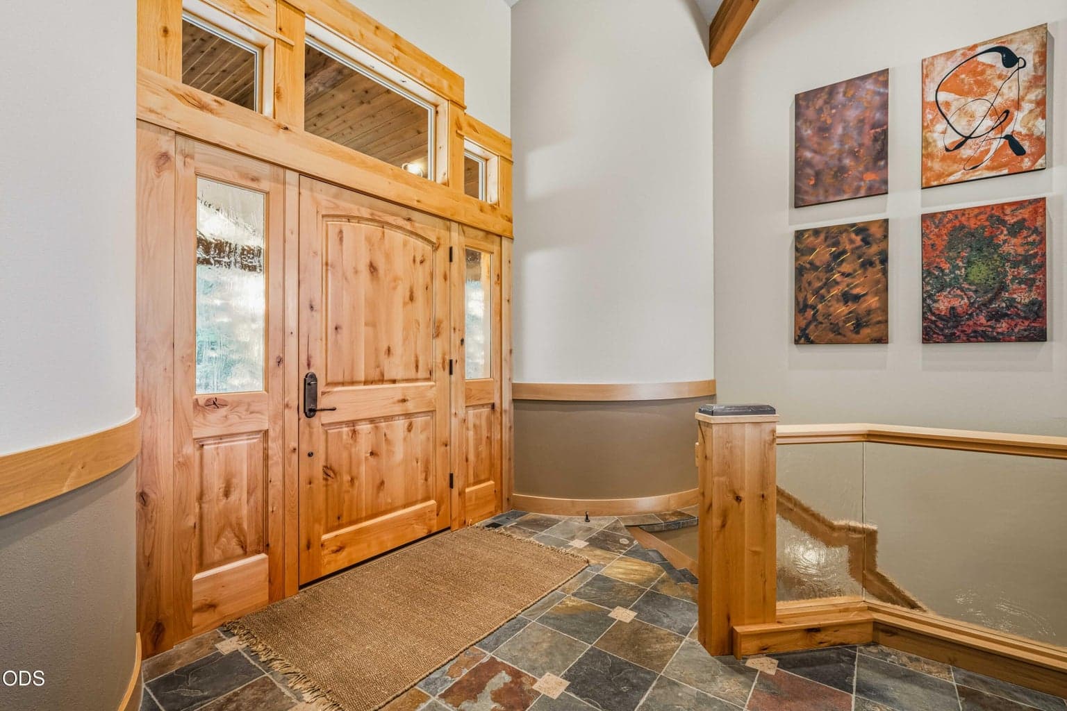 Inside the entry, slate flooring, custom woodwork, art walls and textured glass railings immediately establish the home’s artistic character and carefully considered craftsmanship.