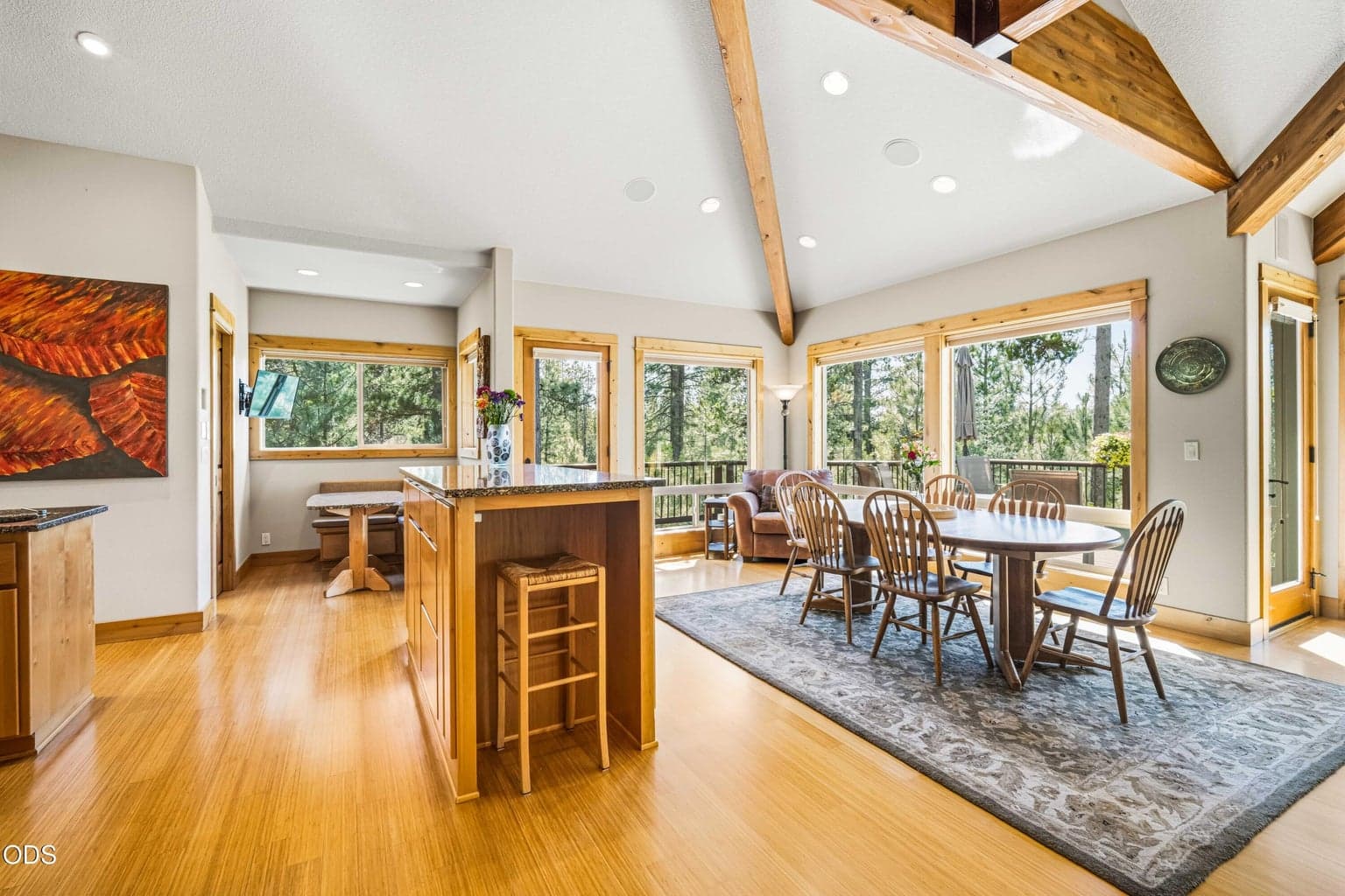 The dining area enjoys direct access to the upper wraparound deck, expansive forest views and an open connection to the kitchen, creating an inviting space for everyday meals and larger gatherings.