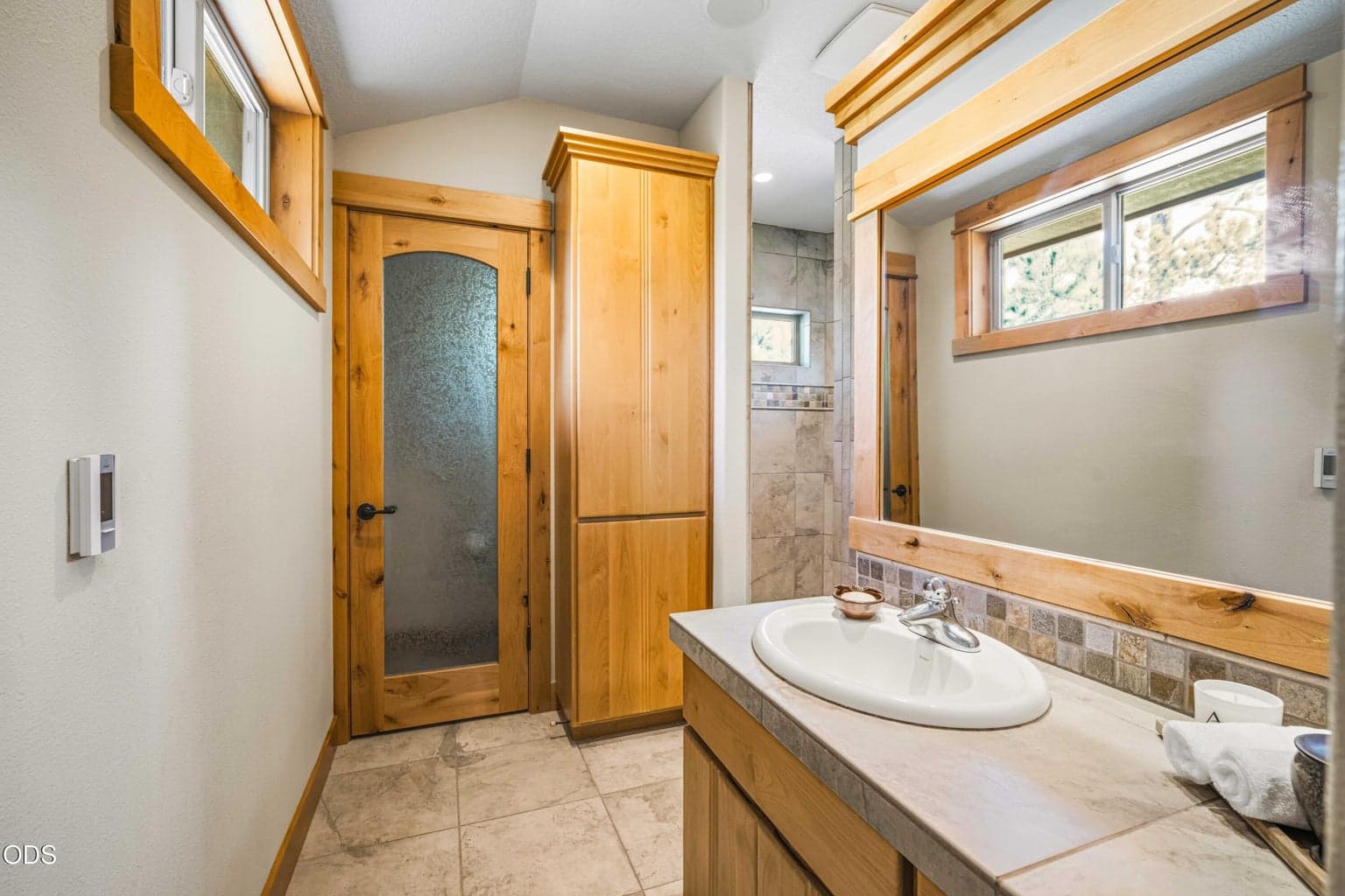 One of two separate dressing areas within the primary suite, this space includes its own vanity, extensive built-in drawers, open shelving and direct access to the shared bath and oversized walk-in closet.