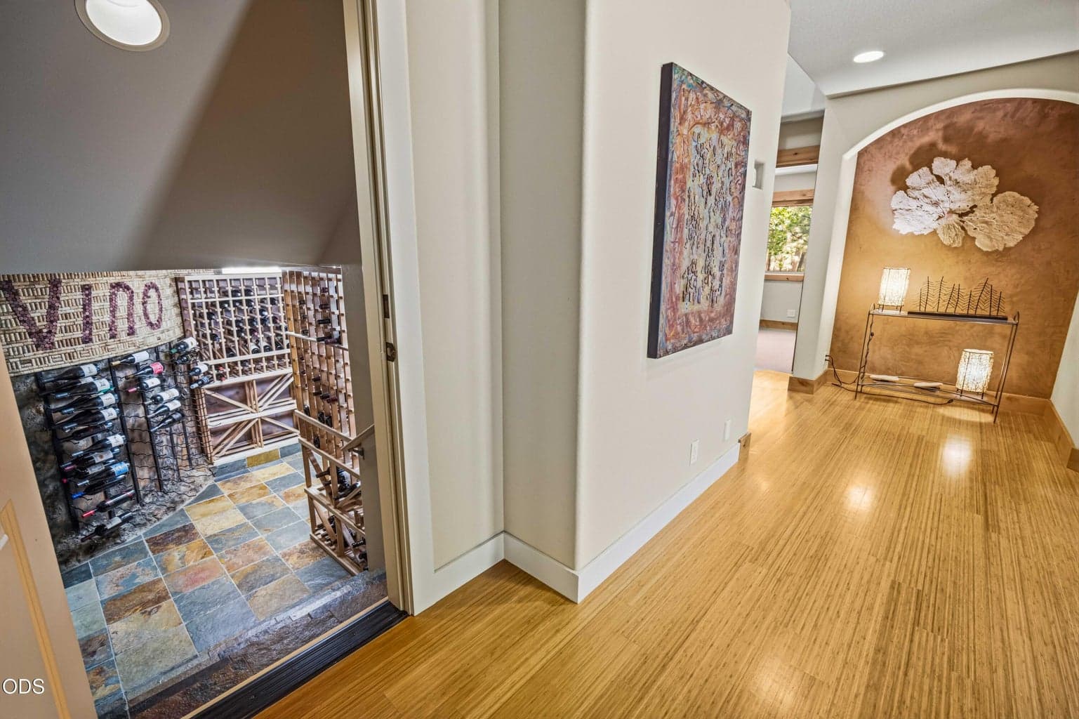 A discreet doorway off the lower hall reveals one of the home’s most memorable amenities, a dedicated wine cellar tucked beneath the stair structure.