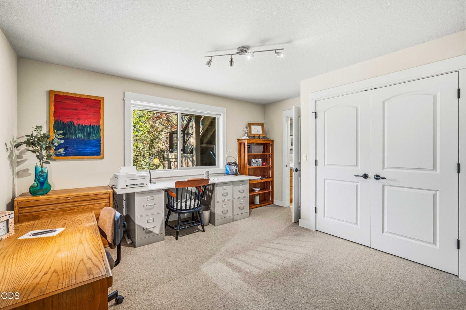 One of two lower-level guest suites, this true bedroom is currently used as a spacious office and creative workspace. A large forest-facing window, generous closet storage and direct access to its own private vanity and toilet area allow it to function comfortably as either a bedroom or dedicated home office.