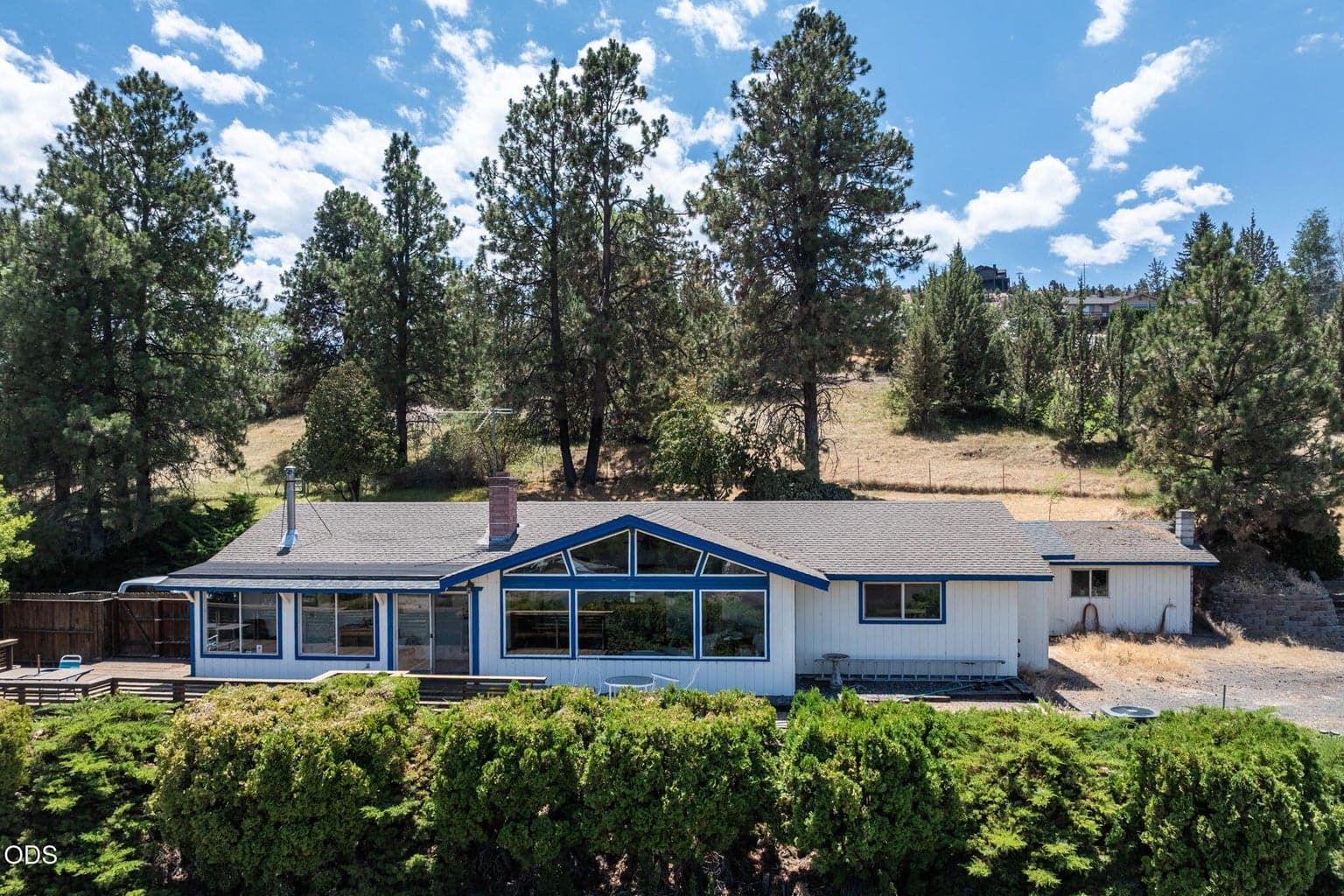 Aerial view of the home, with the fenced pasture above