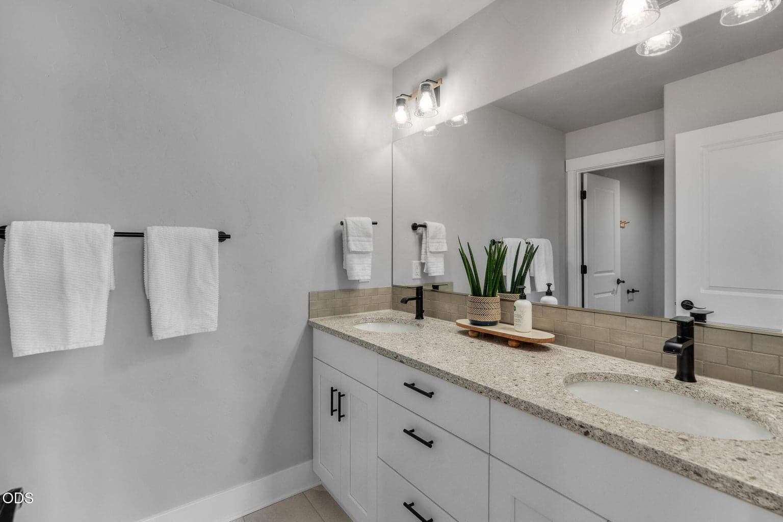second floor hall bathroom with double sinks, solid surface counters, updated hardware and lighting