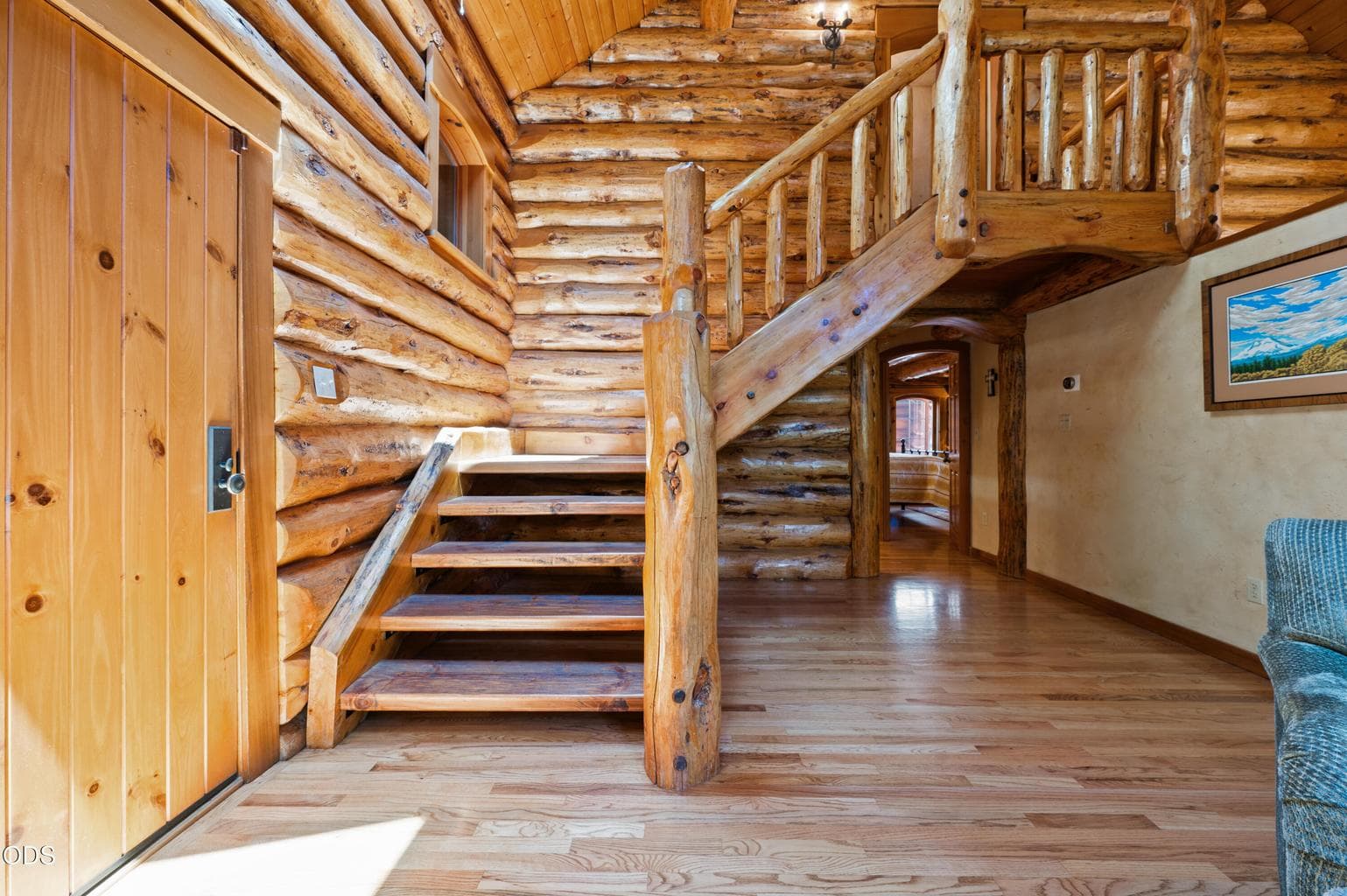 Handcrafted log stairs showcase the home’s authentic craftsmanship and lead to the private upstairs primary suite.