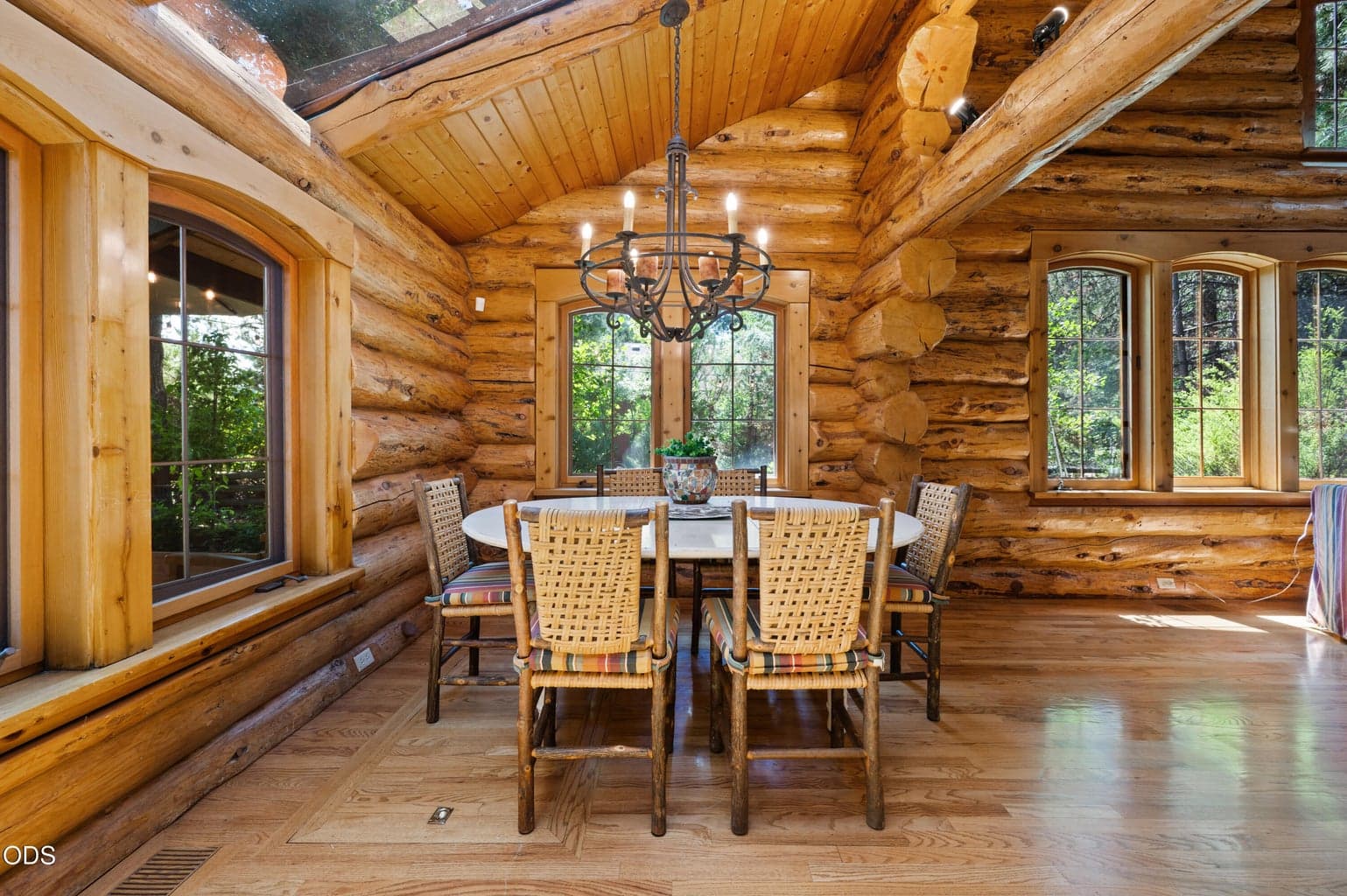 The light-filled dining room is surrounded by windows and enhanced by skylights, creating a seamless connection to the outdoors.