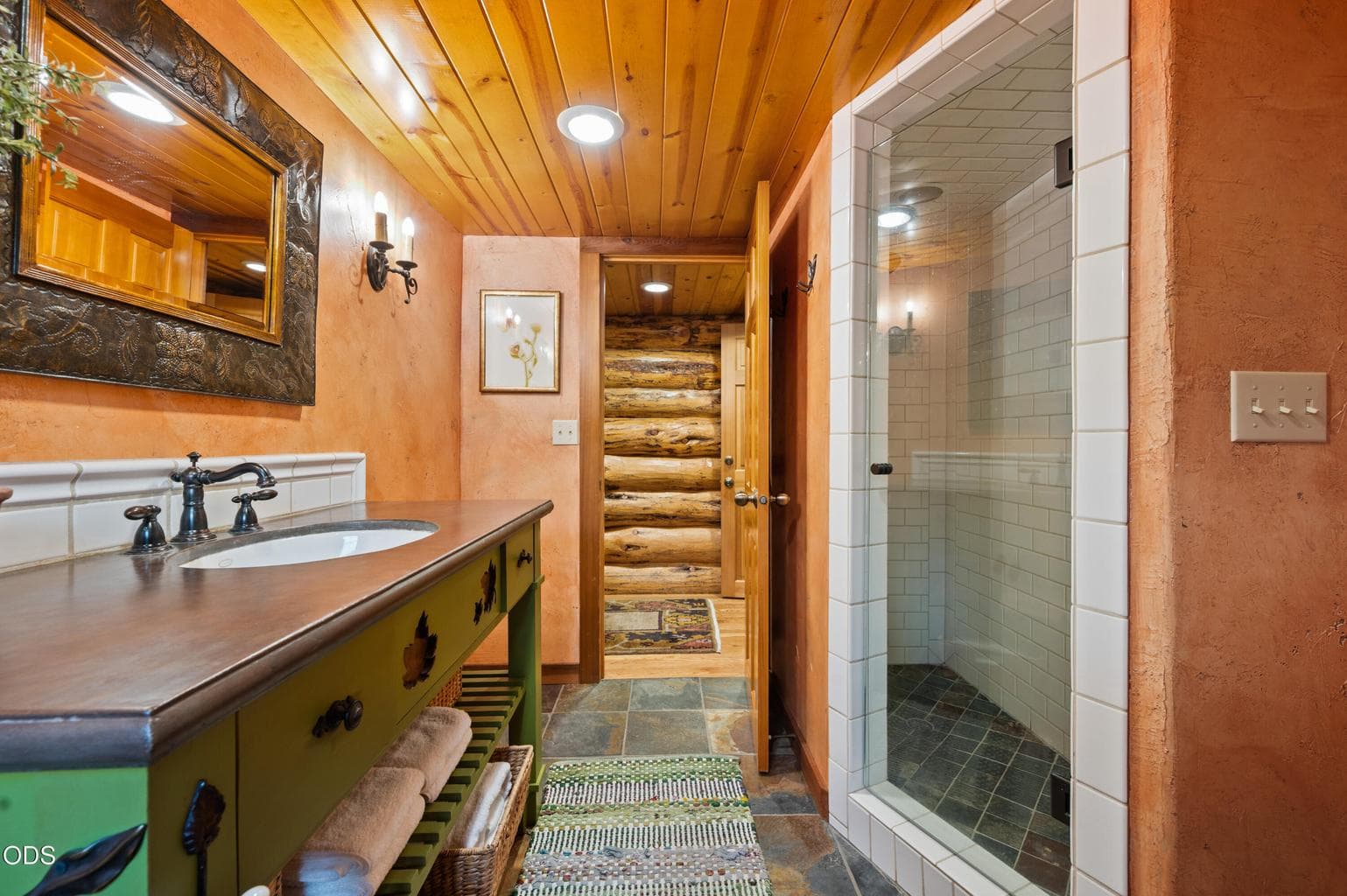 This full bath features custom vanity and tile shower.