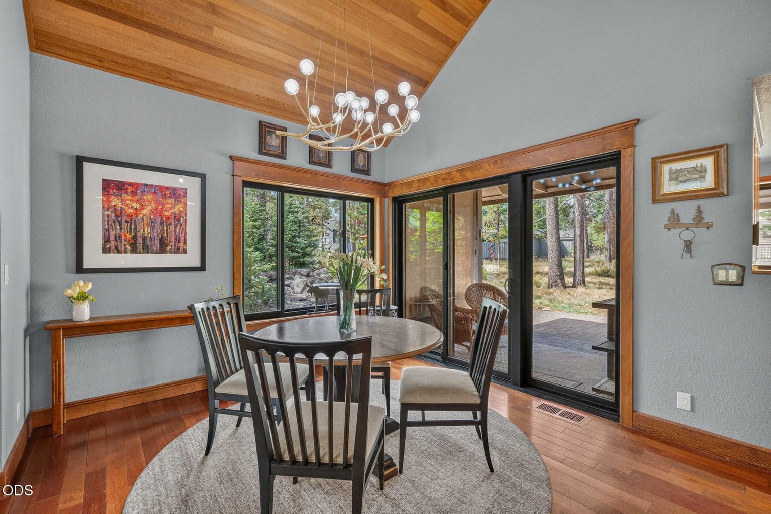 Dining area framed by views to the outdoors, the water feature and a modern chandelier elevates the style - perfect for memory making entertaining.