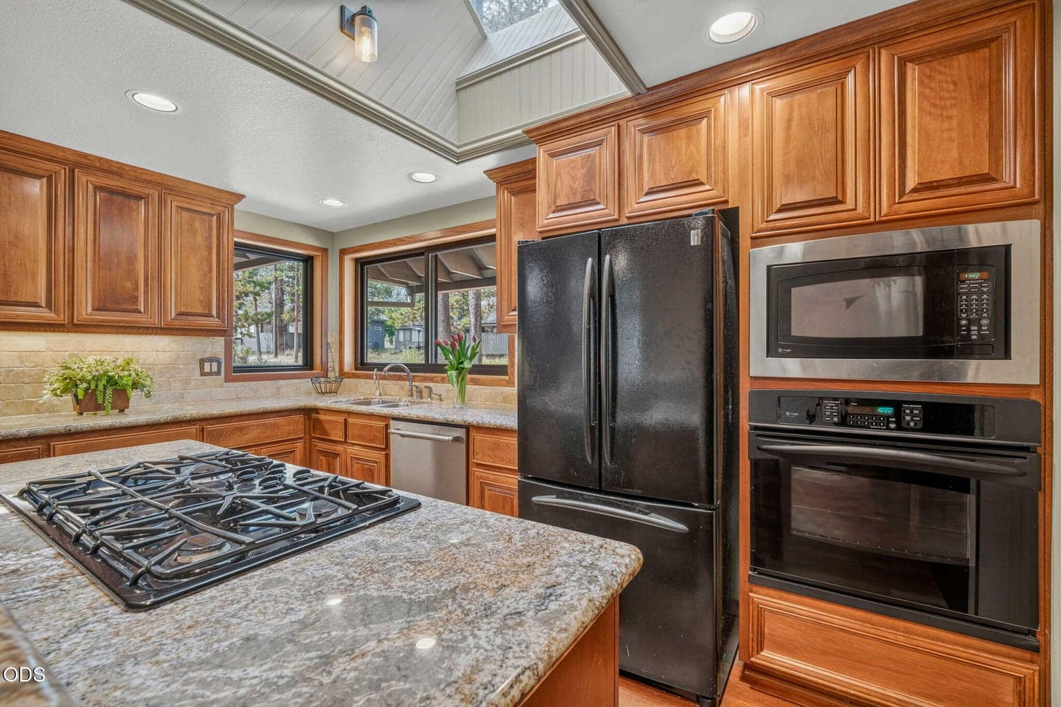 Granite counters, skylight, and rich wood cabinetry define this bright, functional kitchen.