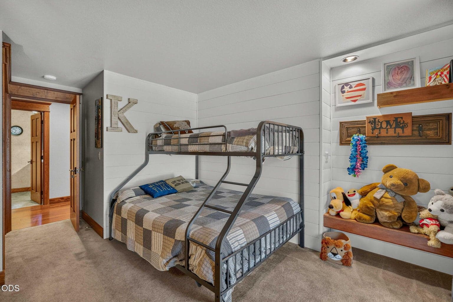 Inviting bunk room with shiplap walls, built-ins, recessed feature lighting and a bench for your favorite things.