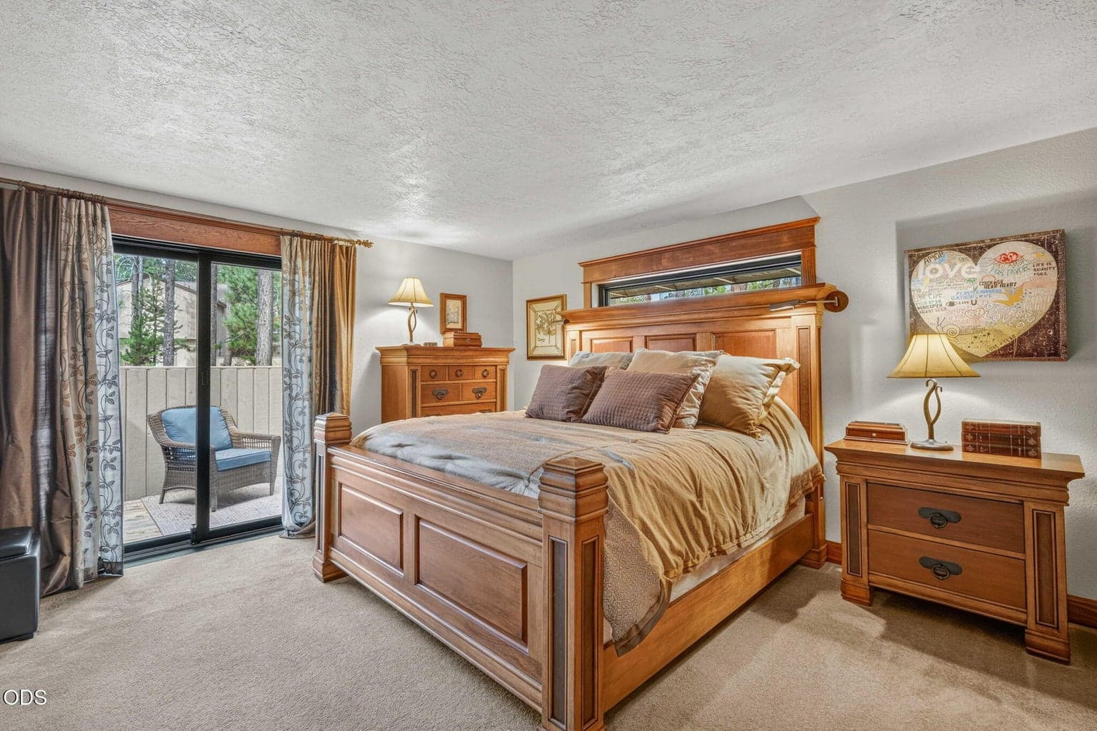 Main level primary suite has a private deck, featured here easily fitting a 4 piece bedroom set with king size bed.