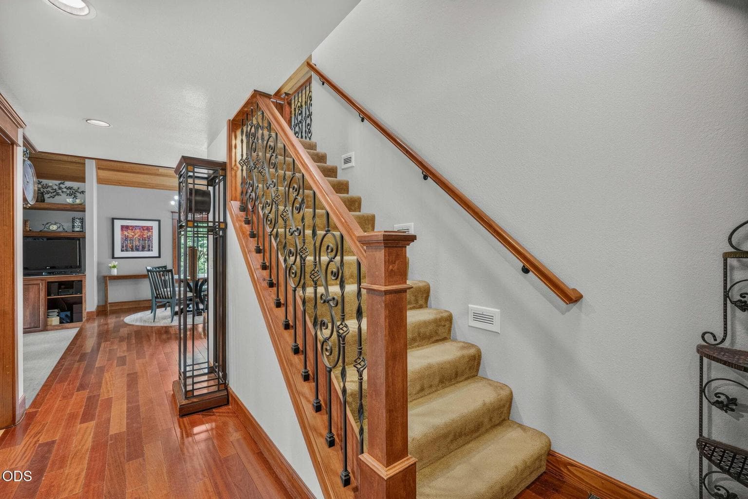 Hallway and stairs framed by custom ironwork and wood accents - classic craftsmanship.