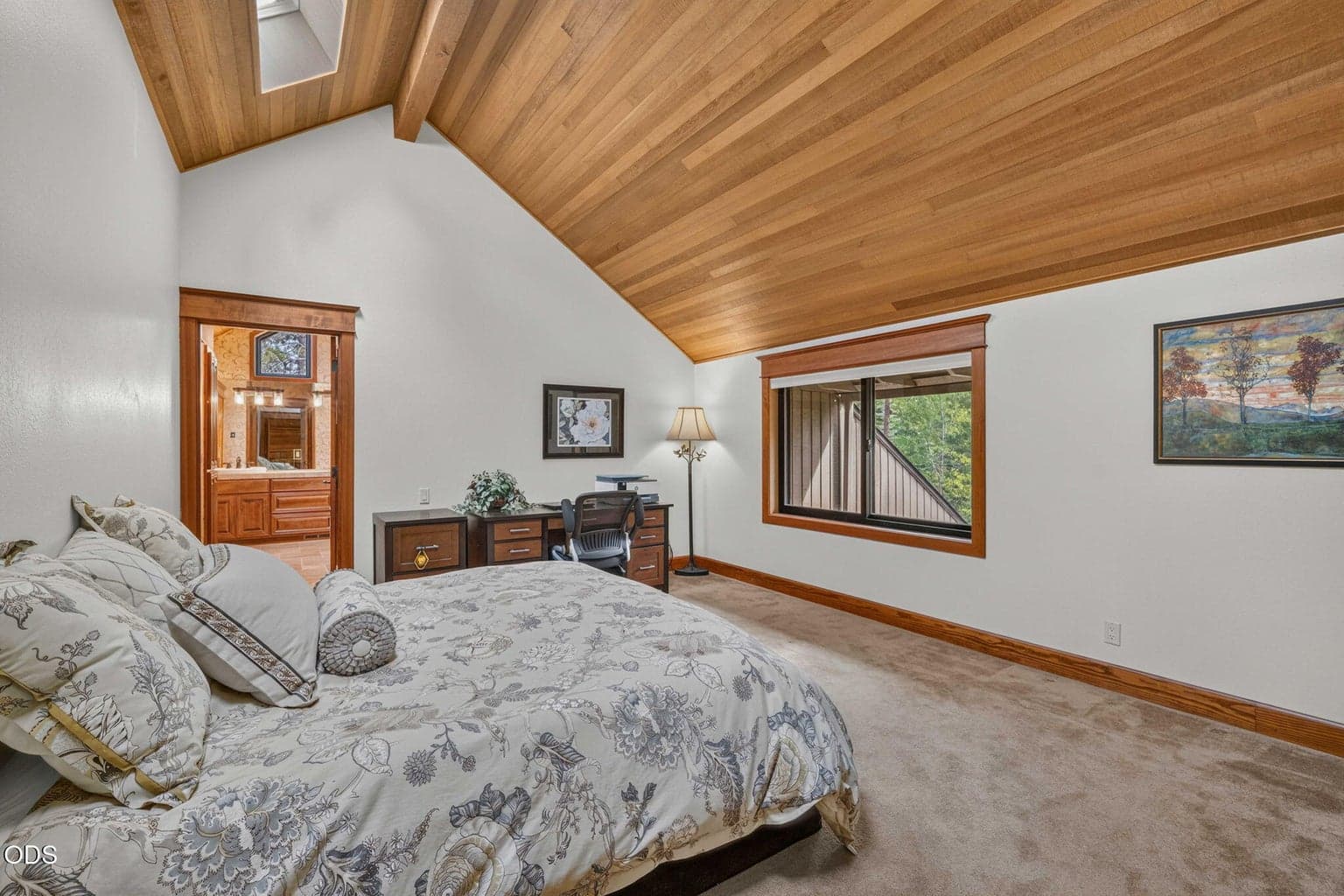 King sized upper level primary suite with skylights and remote blinds - ideal for rest , relaxation or quiet workspace.