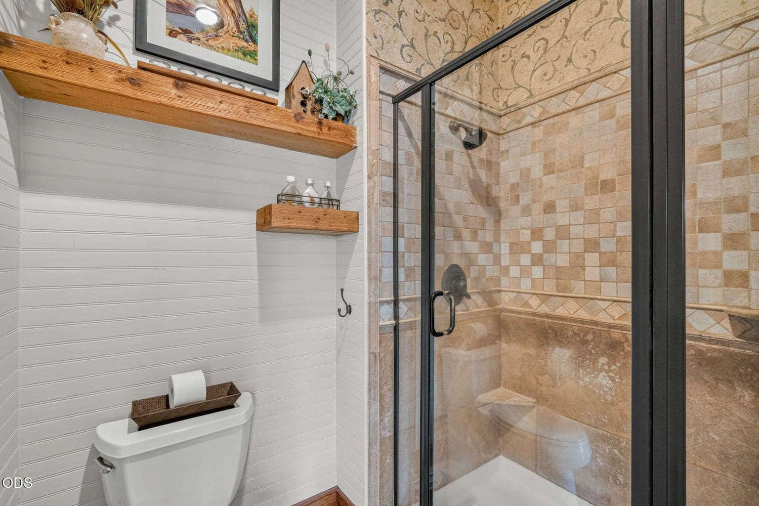 Tiled shower and private toilet room with rustic shelving and warm natural textures.