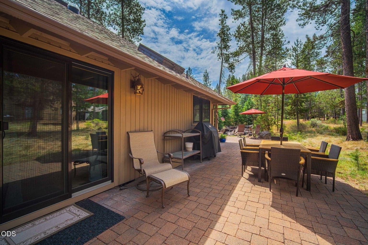 Expansive paver patio nestled among tall pines - ideal for meals al fresco, family gatherings and experiences you'll treasure.