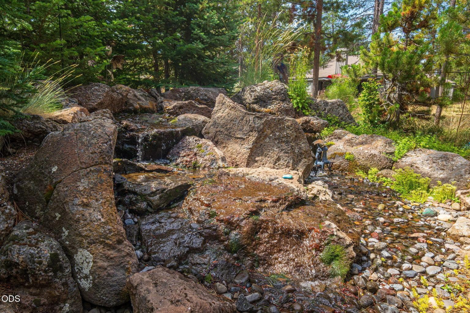 Serene water feature tucked into the evergreens - wild birds frequent it daily, creating a lively Sunriver backdrop.