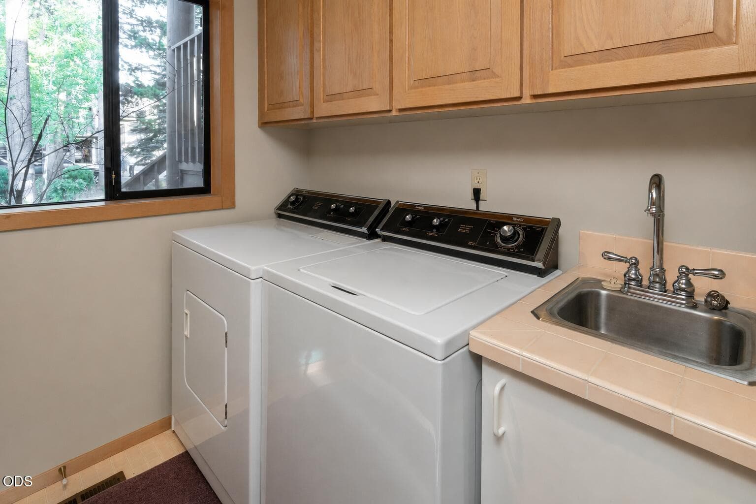 The Laundry/Mudroom w/its own sink. and lots of cabinet space. Laundry chute upstairs conveniently drops the items to be laundered on demand!