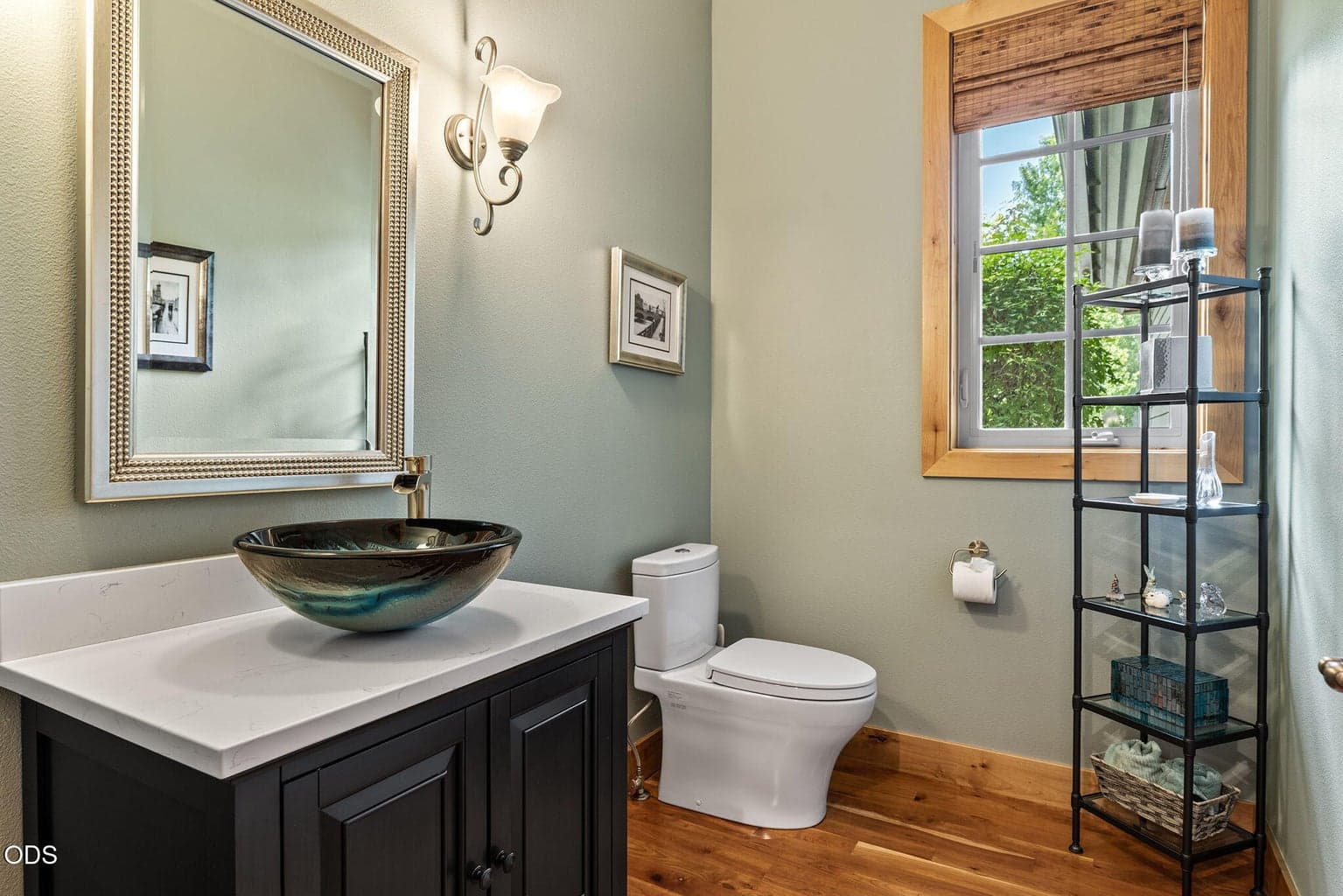 The updated powder bath showcases a custom glass vessel sink and solid surface vanity.