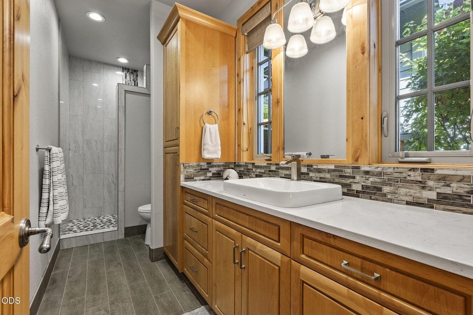 Guest bath updates included solid surface counter tops and reconfigured shower enclosure with porcelain tile and a no-door entry.