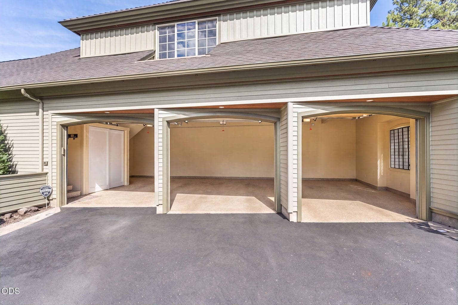 The empty garage view has been AIenhanced, while the new whole-home tankless water heater and humidifier are discreetly housed behind the cabinetry along the left wall.