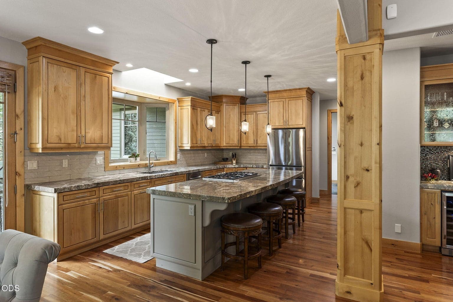 The island cabinetry was elevated with a luxe lacquer finish, creating a striking contrast against the warm Knotty Alder wood.