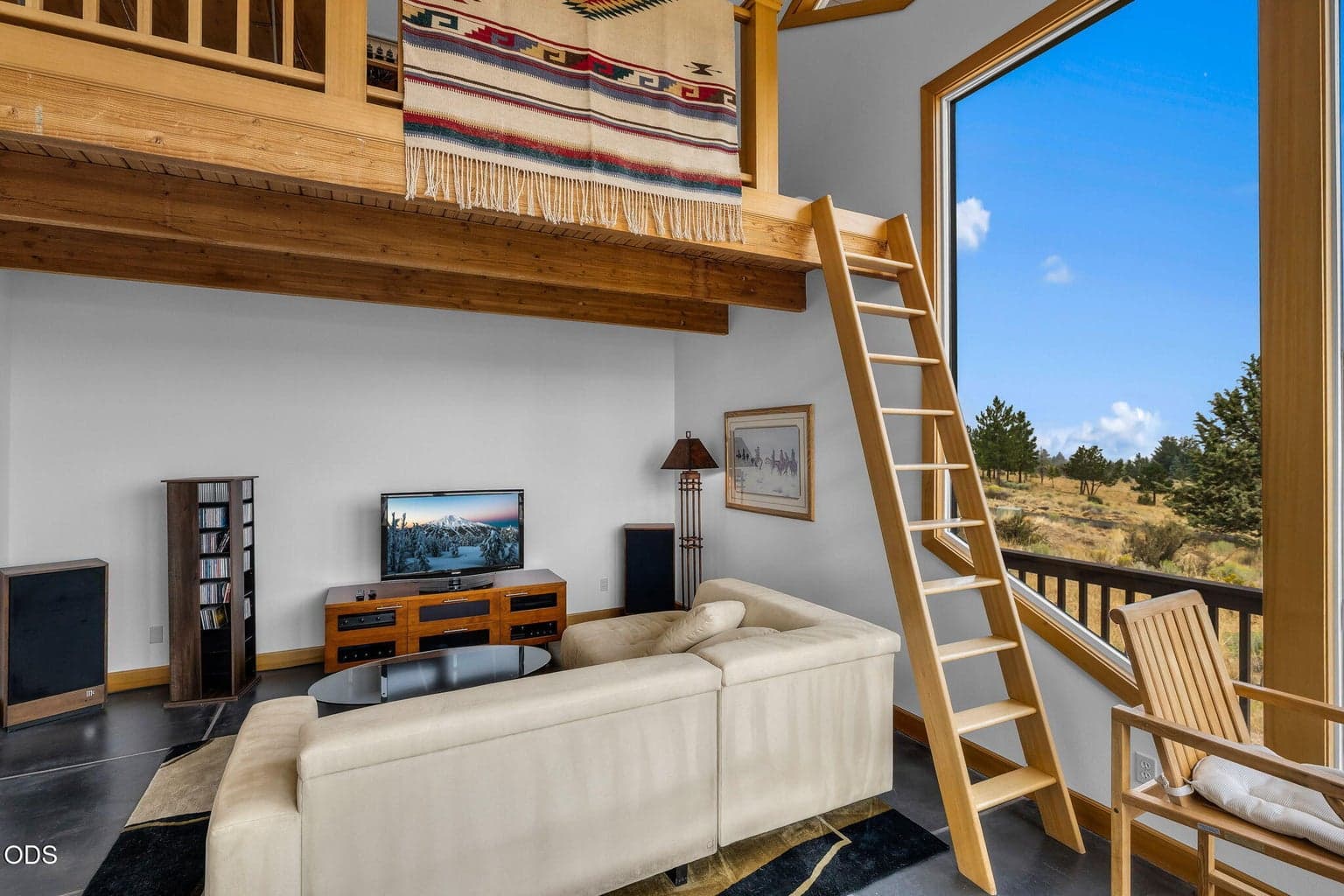 Family room is spacious, with tall windows and a awesome loft